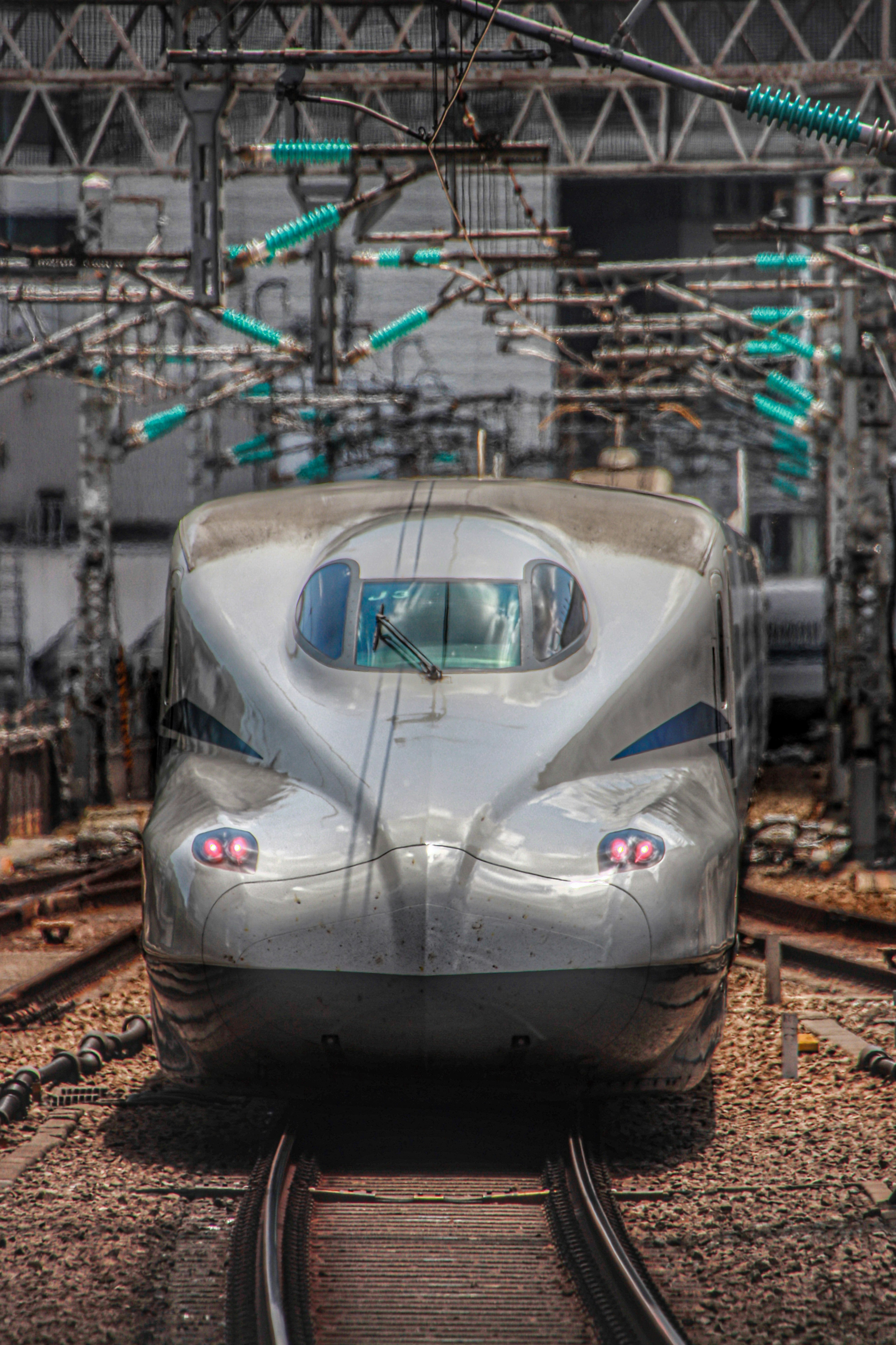新幹線の先頭車両が線路上で停車する車両基地の風景