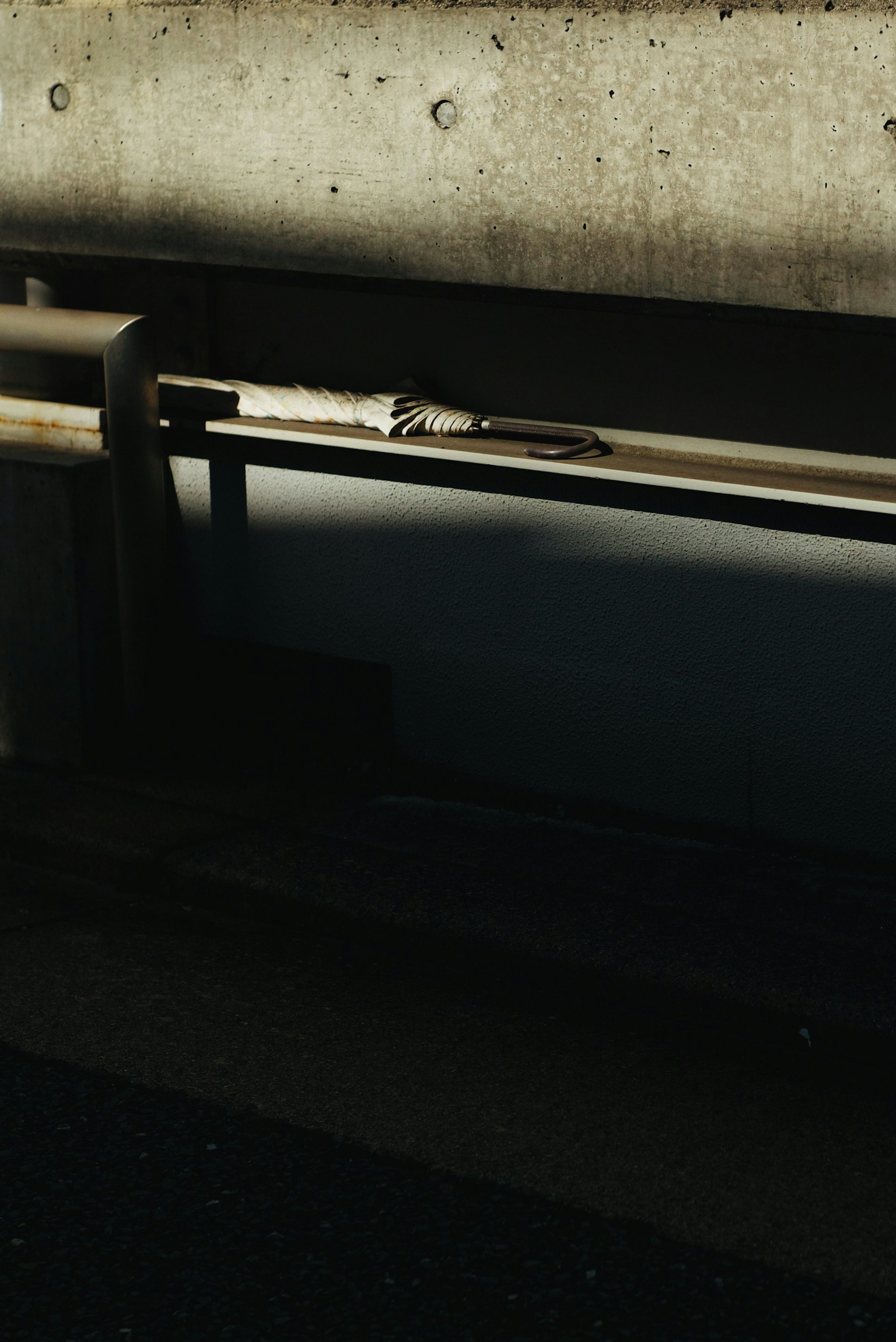 コンクリートの壁と金属のパイプが見える暗い背景の画像