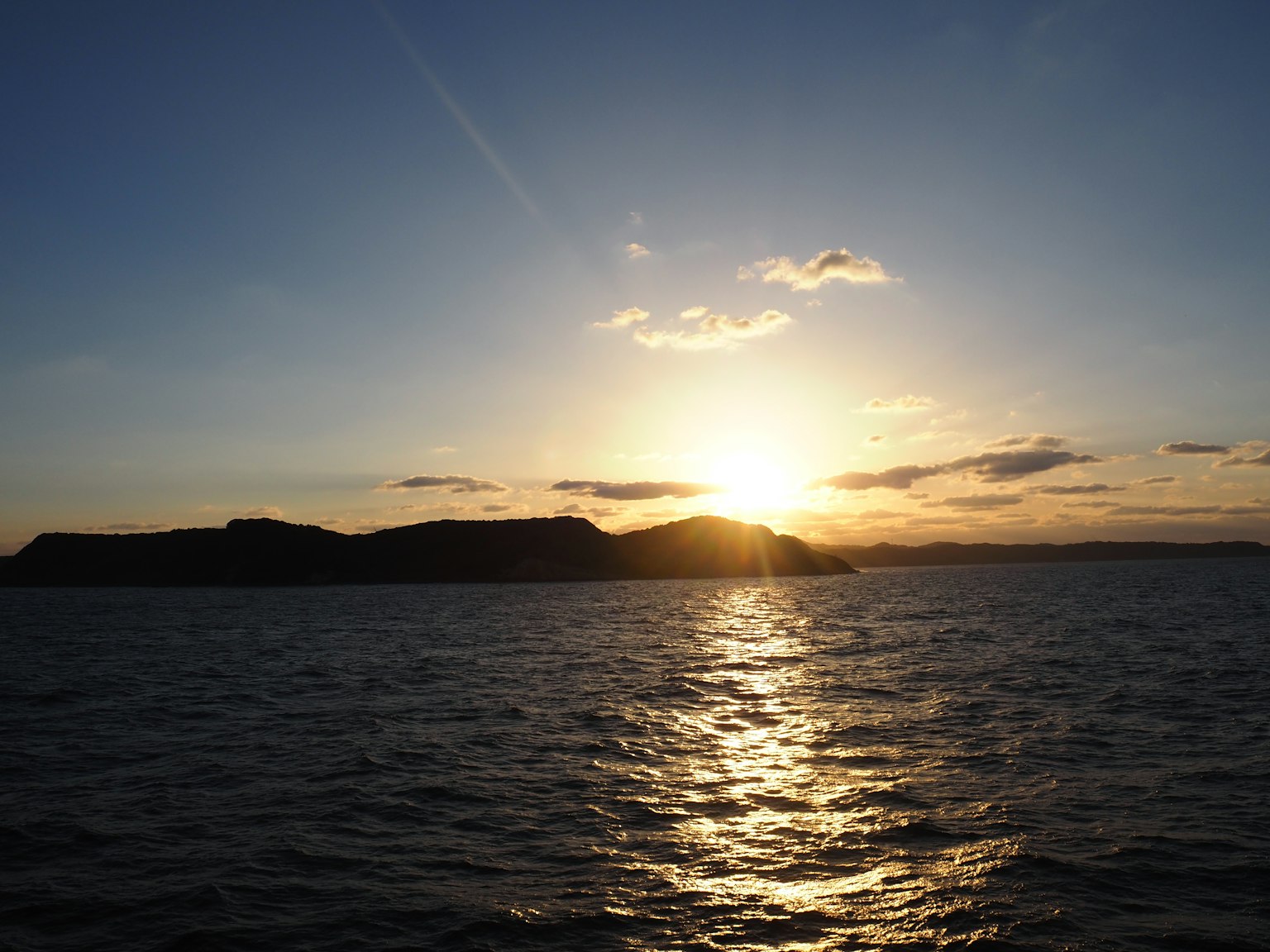 Ein Sonnenuntergang über dem Ozean mit Silhouetten von Inseln