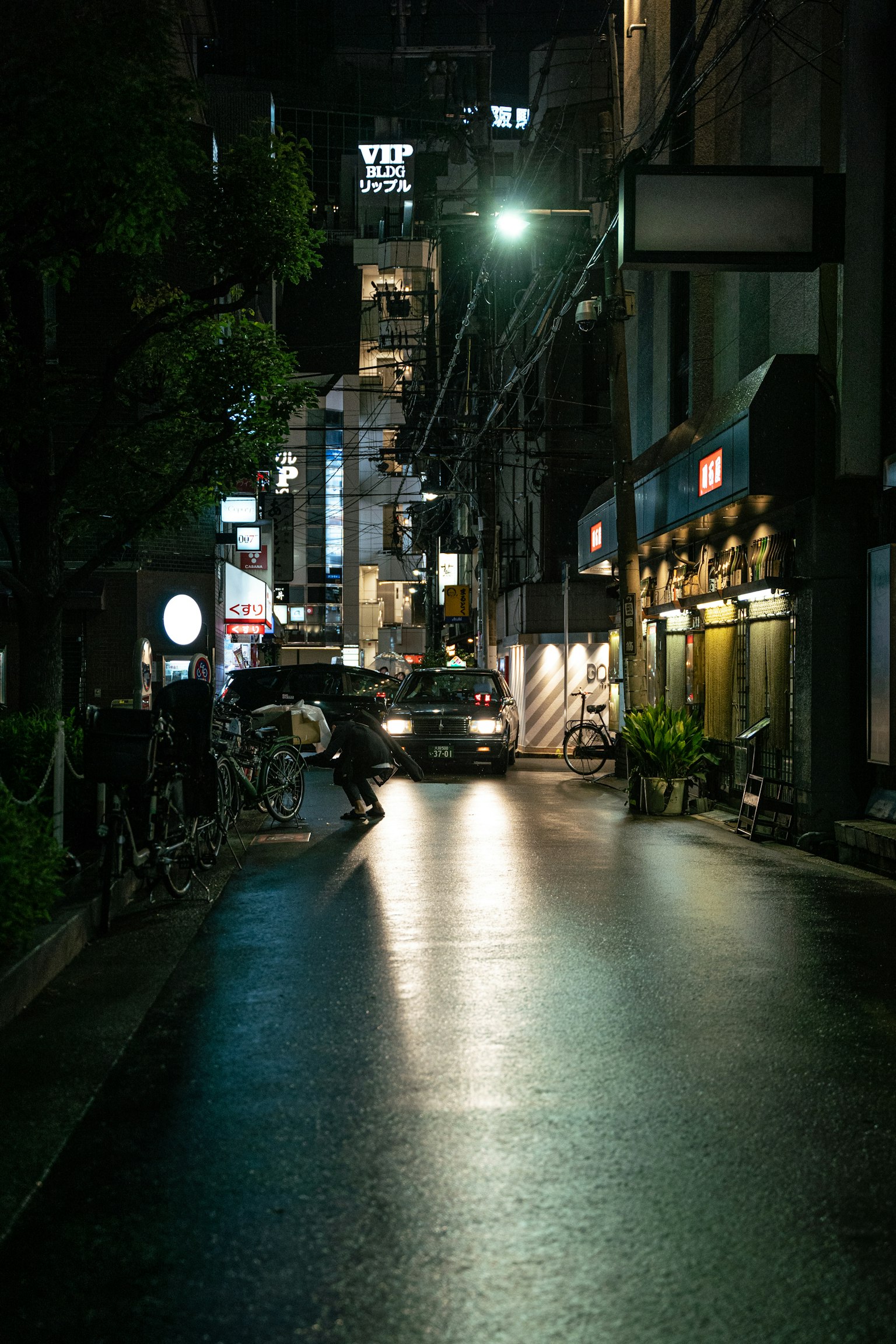 夜间城市街道，闪亮的人行道和商店招牌