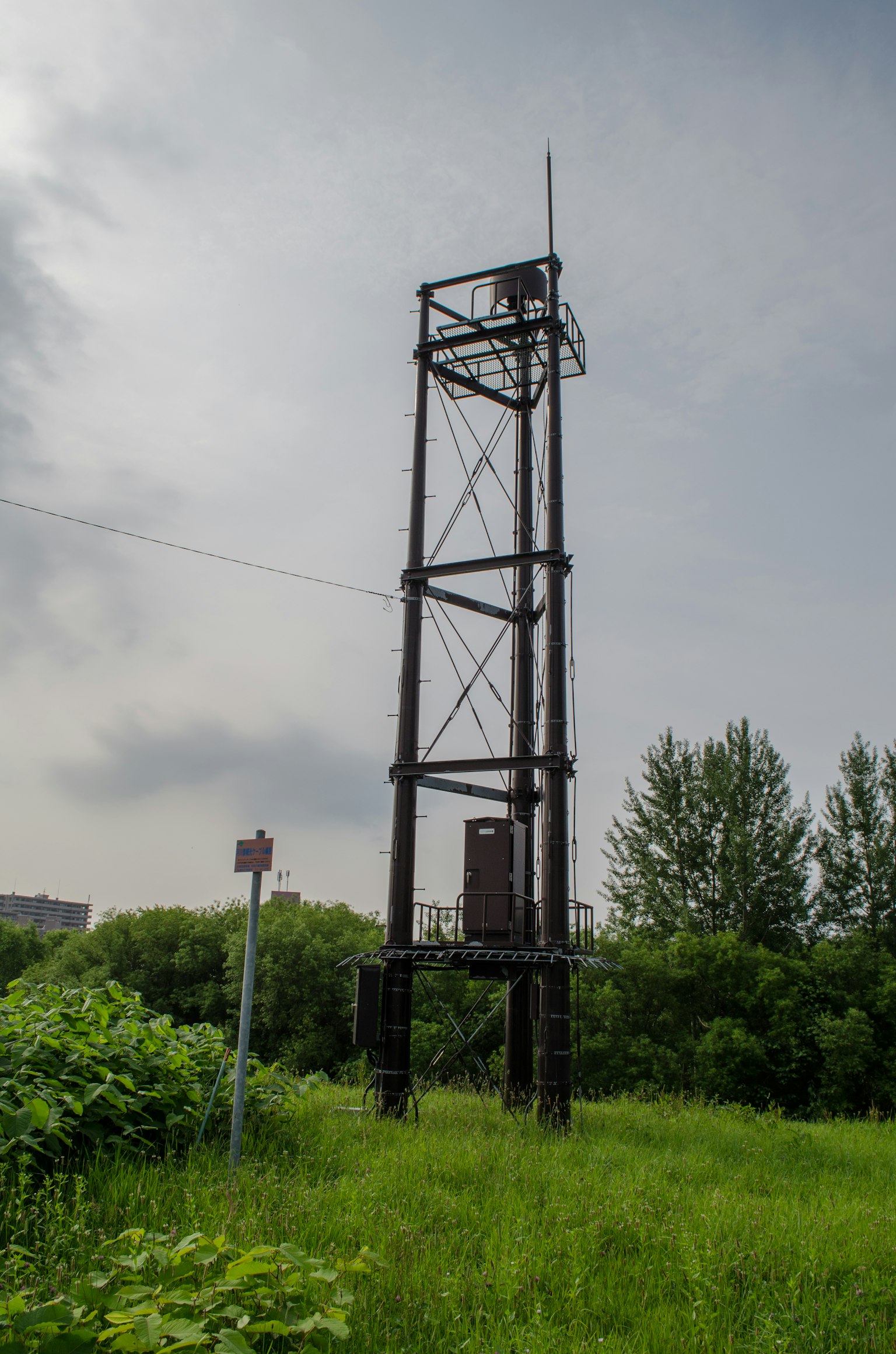 Old communication tower surrounded by grass