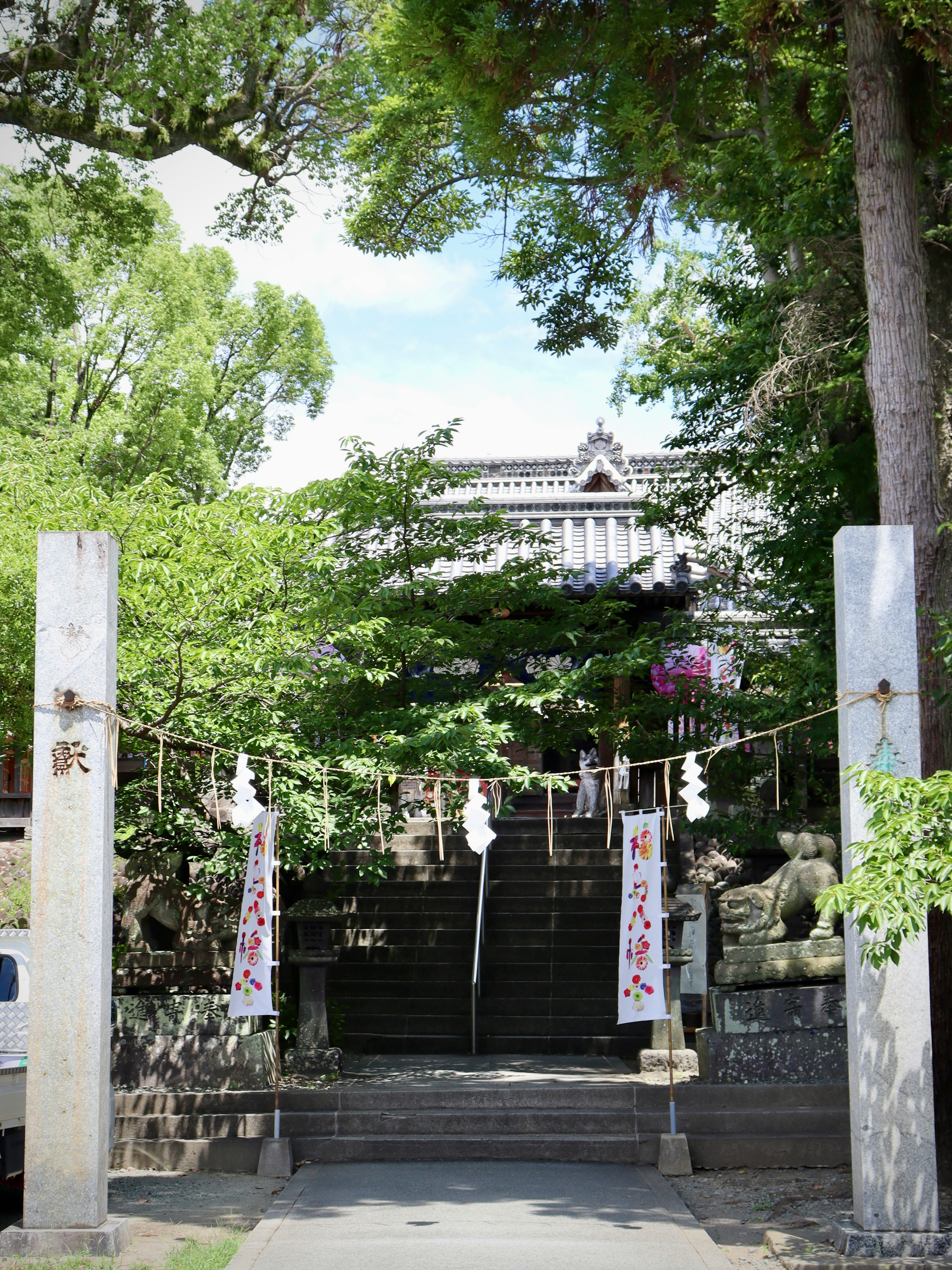 緑に囲まれた石段の神社の参道