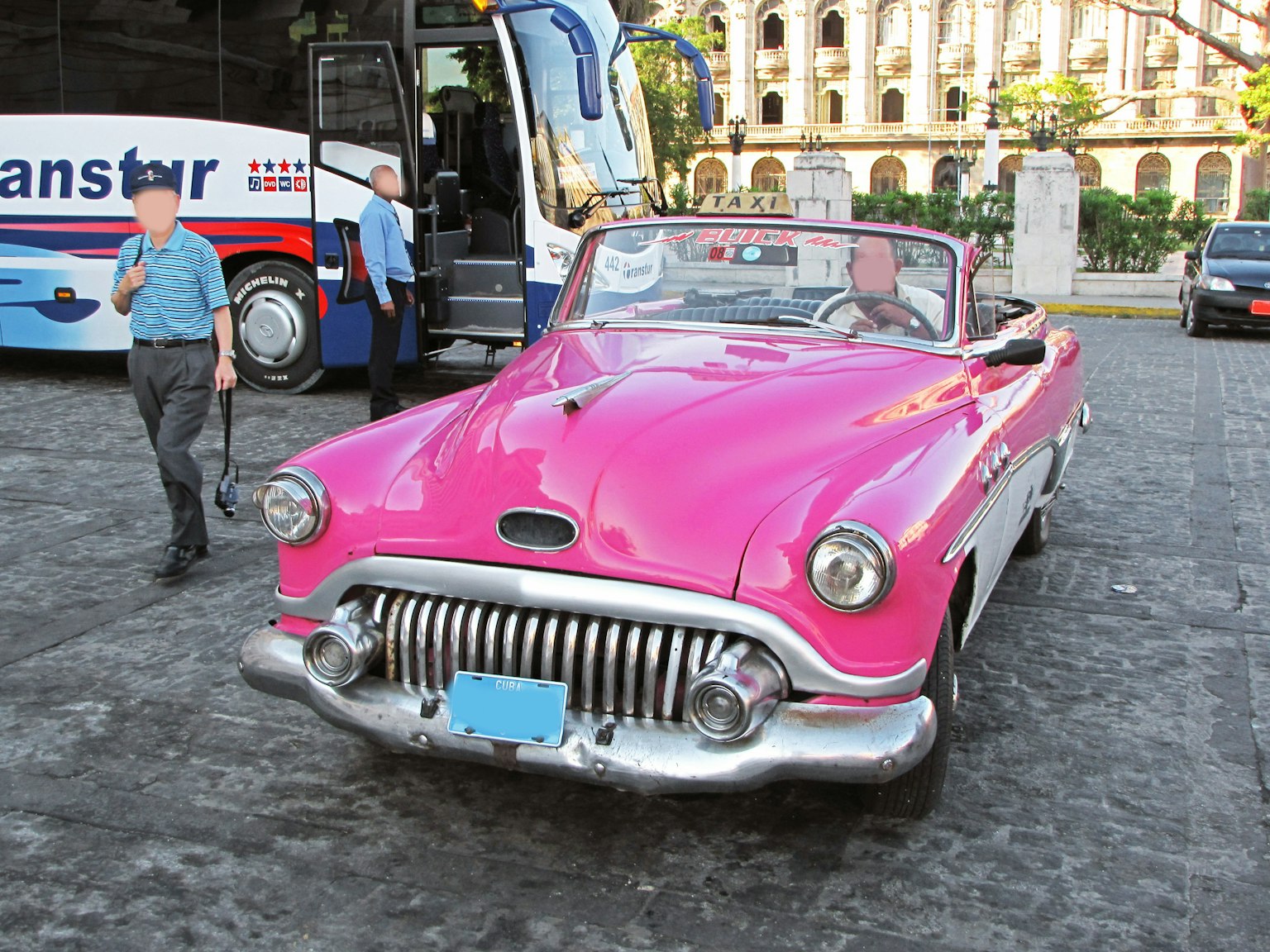 Ein lebhaftes pinkes Cabrio, das auf der Straße geparkt ist