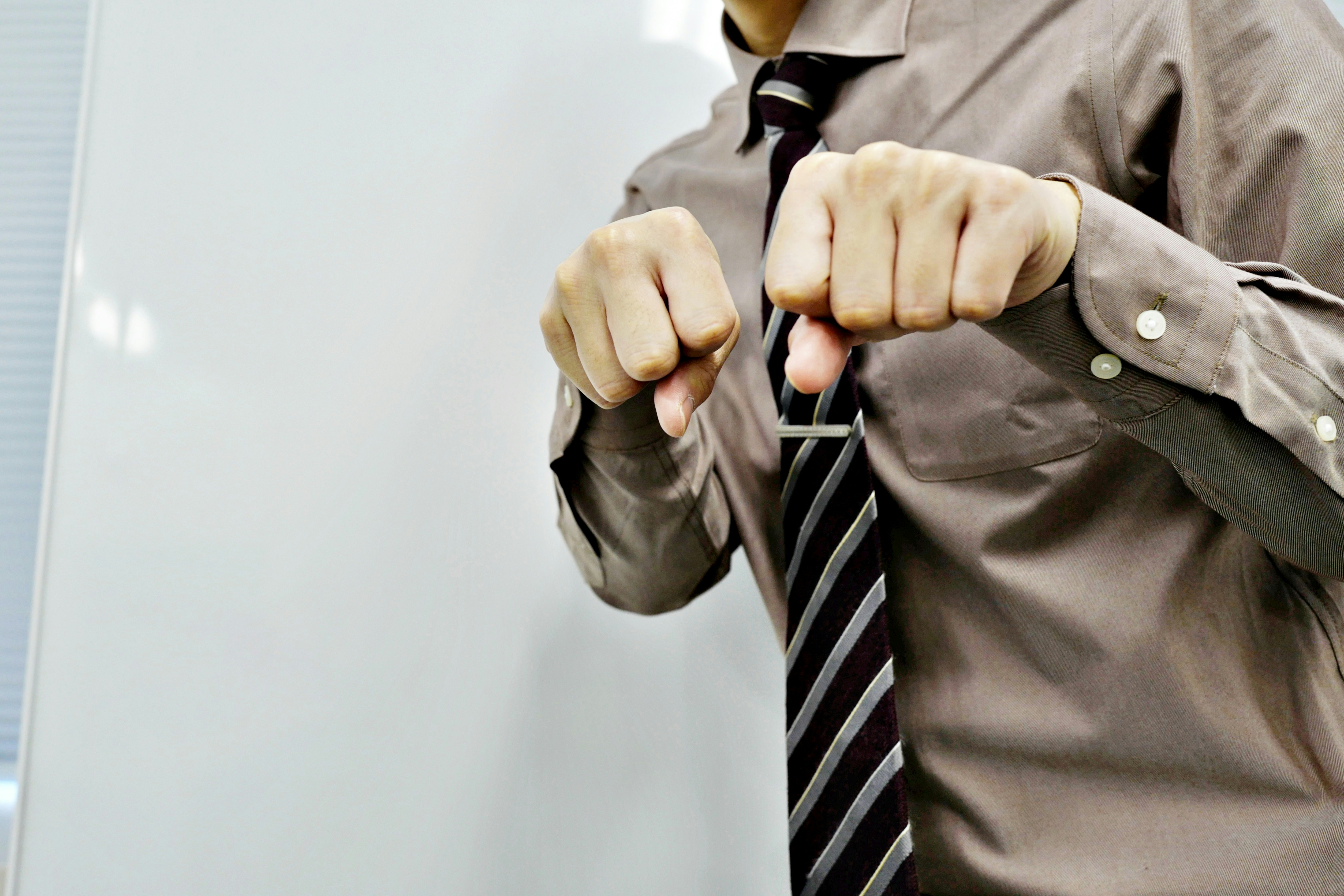 hands adjusting a man’s tie in a suit