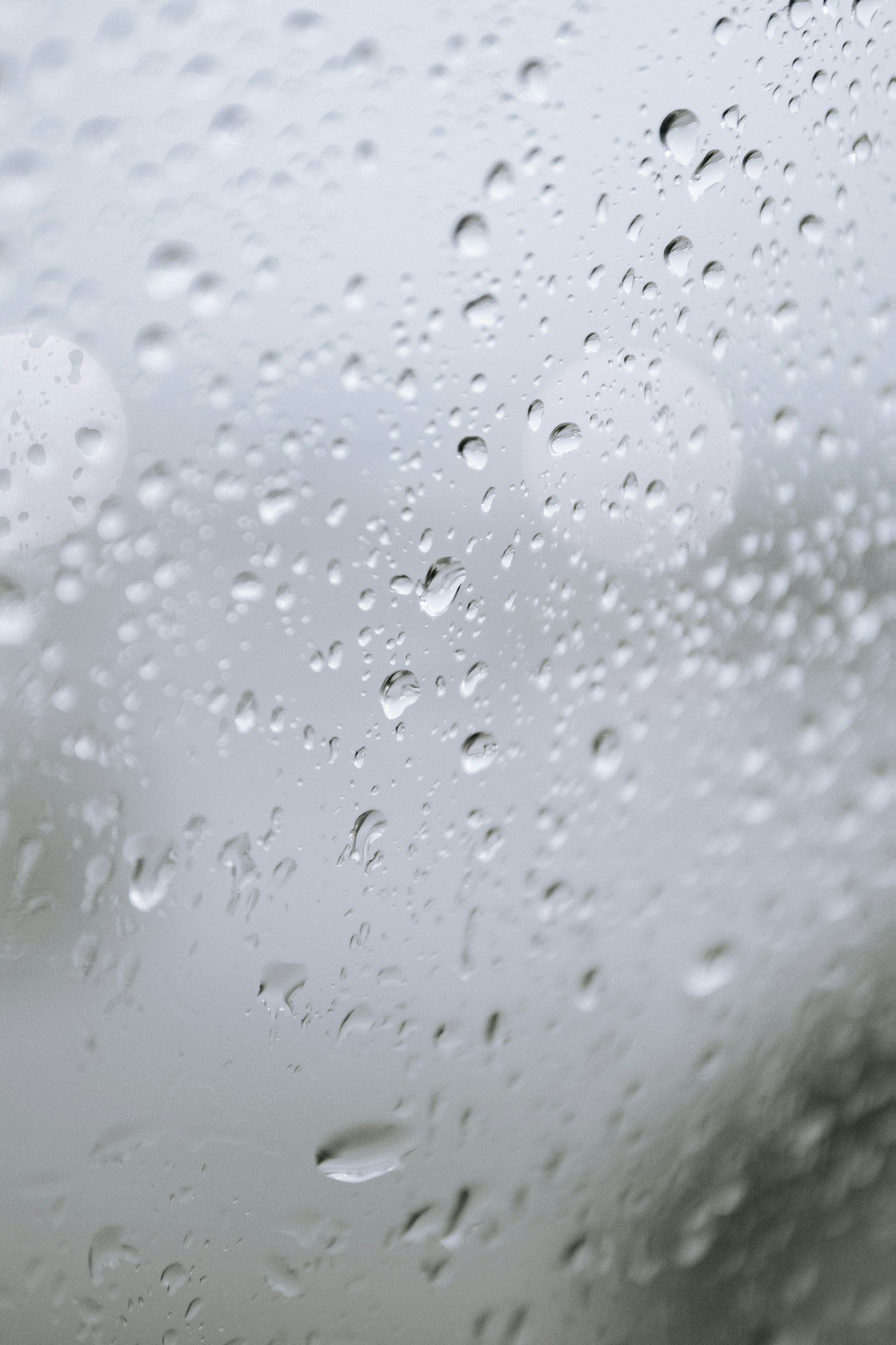 窗戶上的雨滴特寫，背景模糊