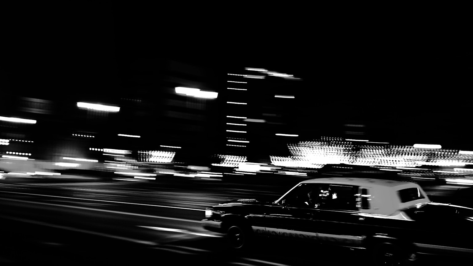 黑白圖像的計程車在夜晚的城市中飛馳