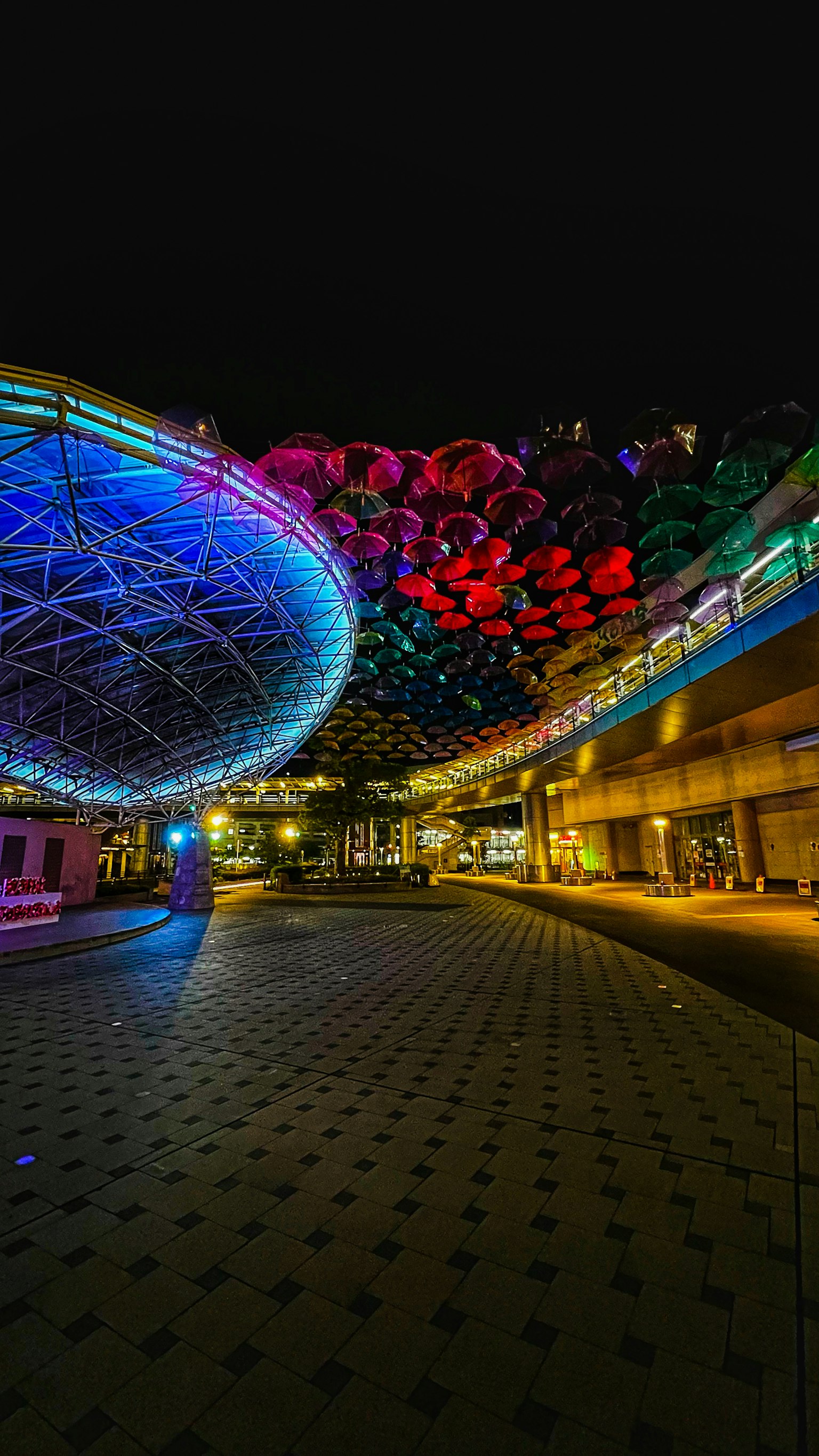Escena nocturna vibrante de una plaza iluminada con luces de colores