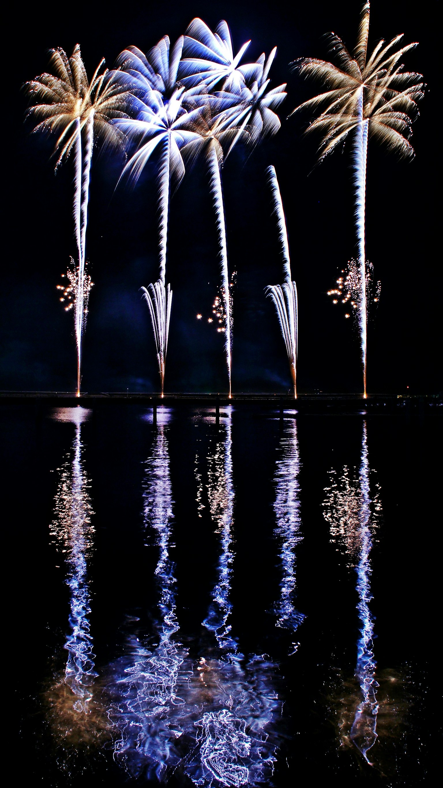 Spectacular fireworks reflecting on water at night