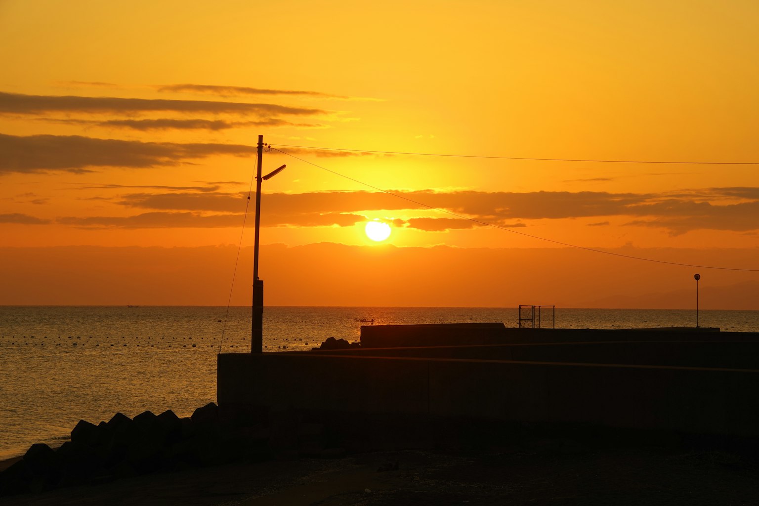 Hermoso atardecer sobre el mar con estructuras en silueta