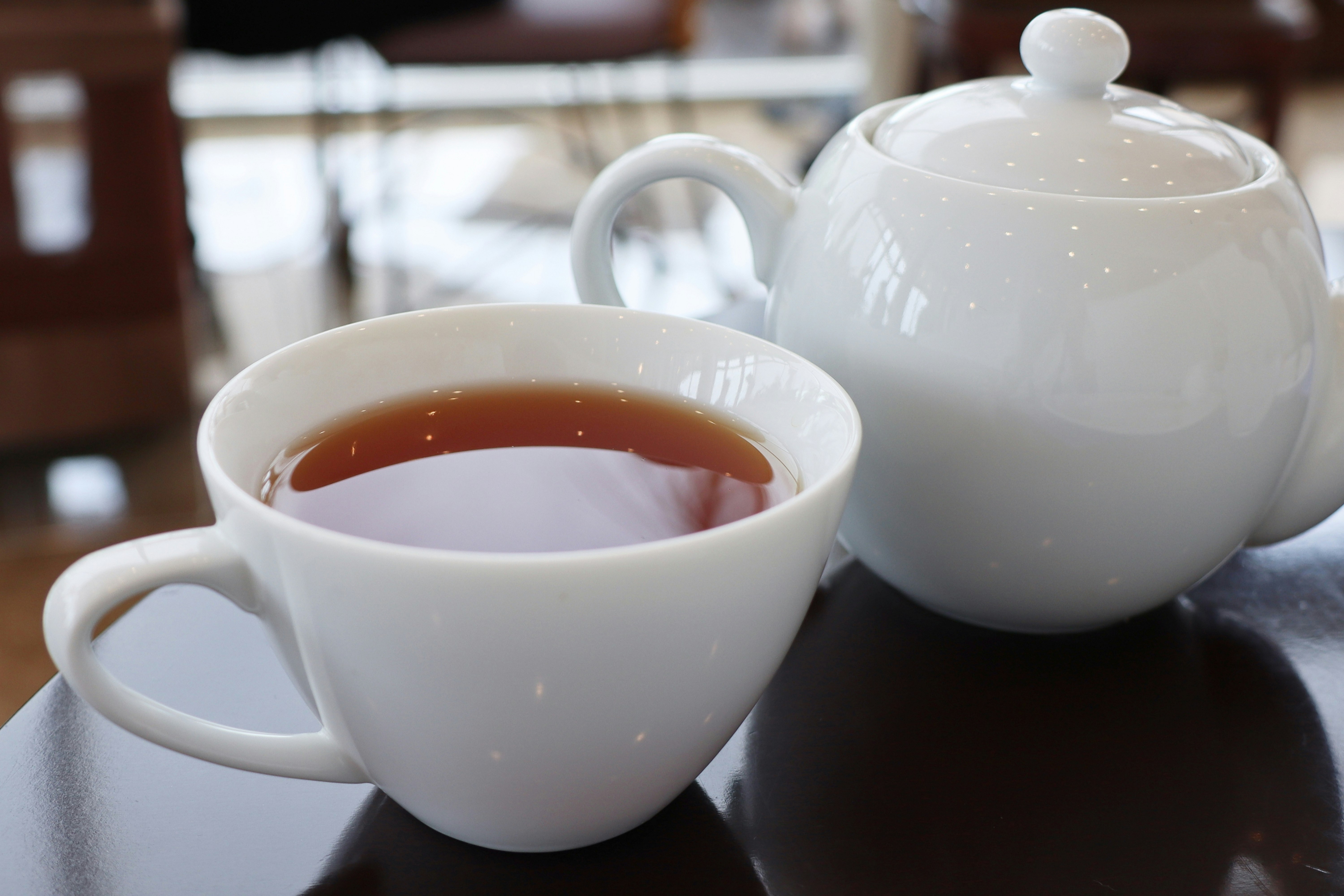 白色茶杯與茶壺旁的紅茶