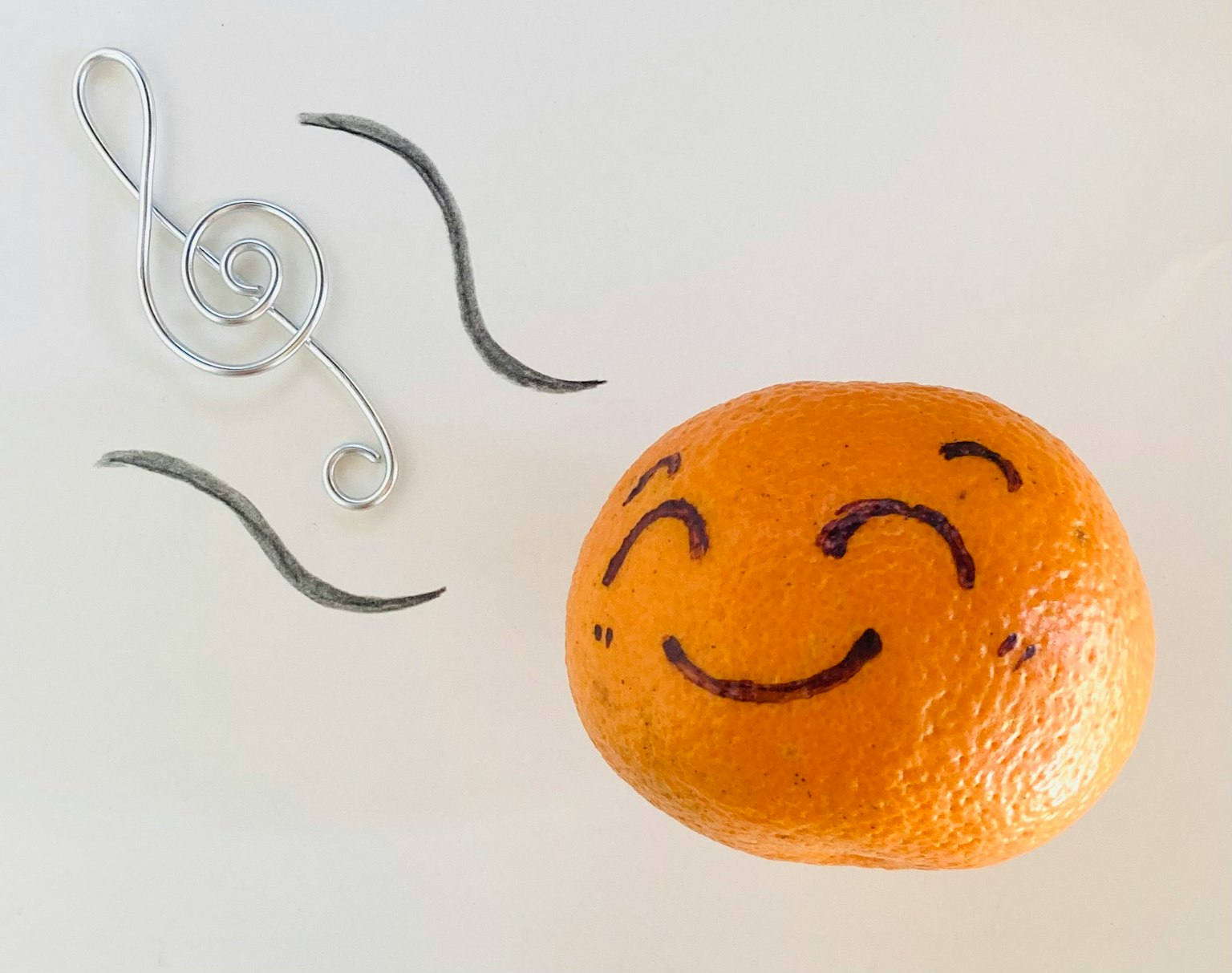Naranja sonriente con notas musicales