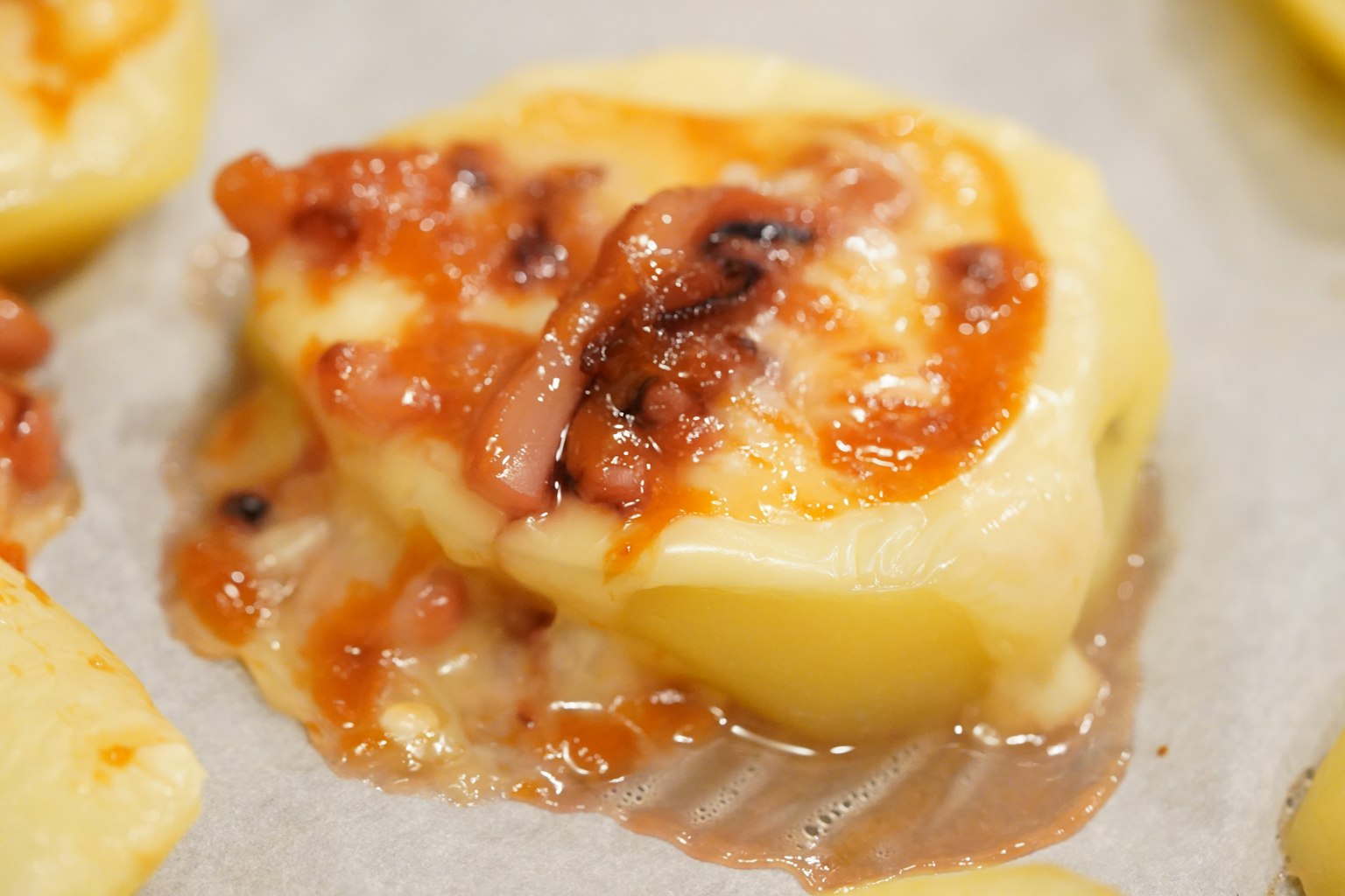 Gebackene Kartoffel mit geschmolzenem Käse und Speck