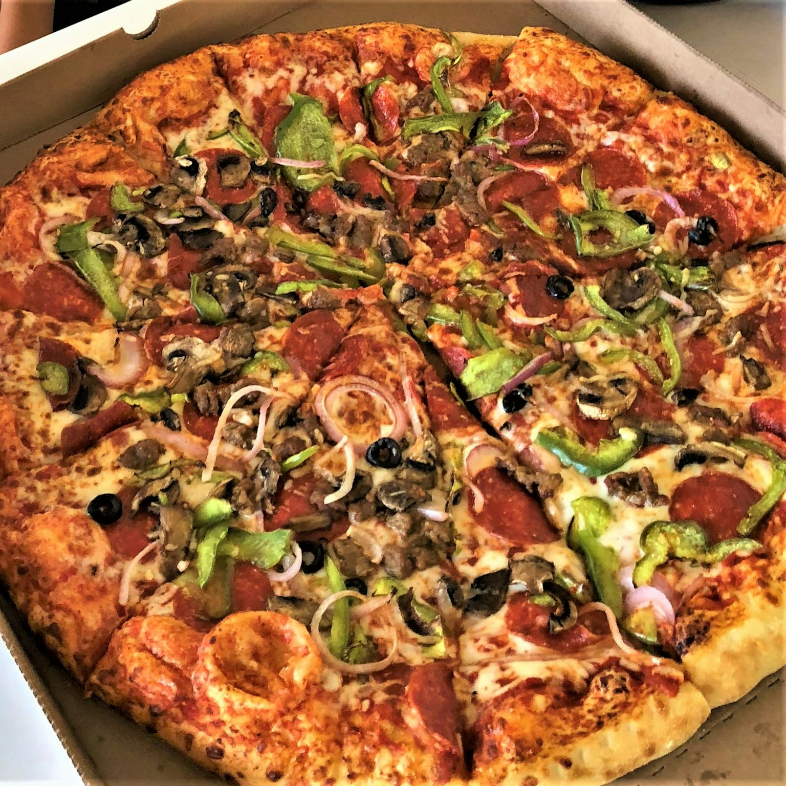 外賣盒中的各種配料的彩色披薩