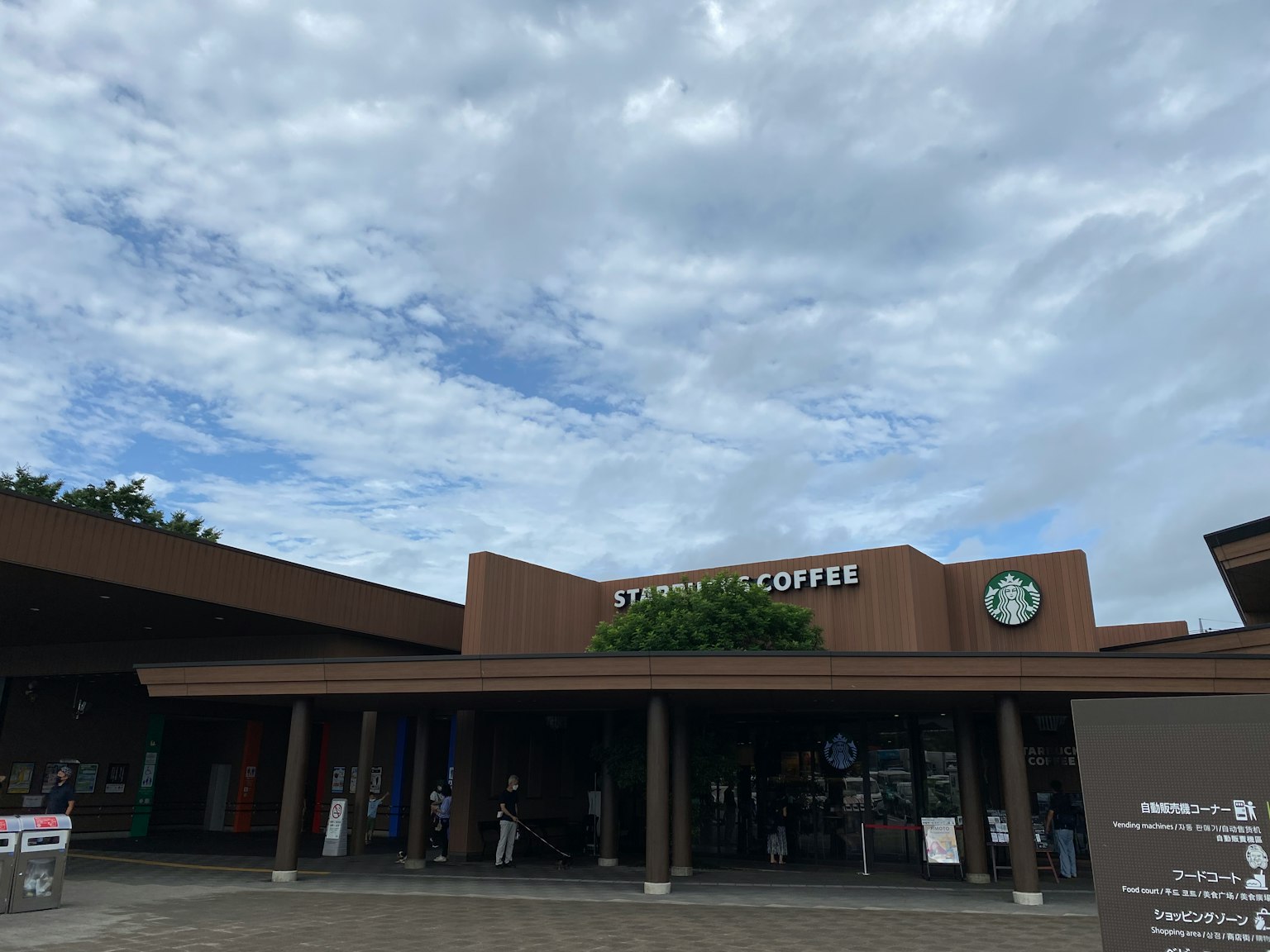 Ngoại thất của Starbucks Coffee với bầu trời xanh và mây, tòa nhà bằng gỗ