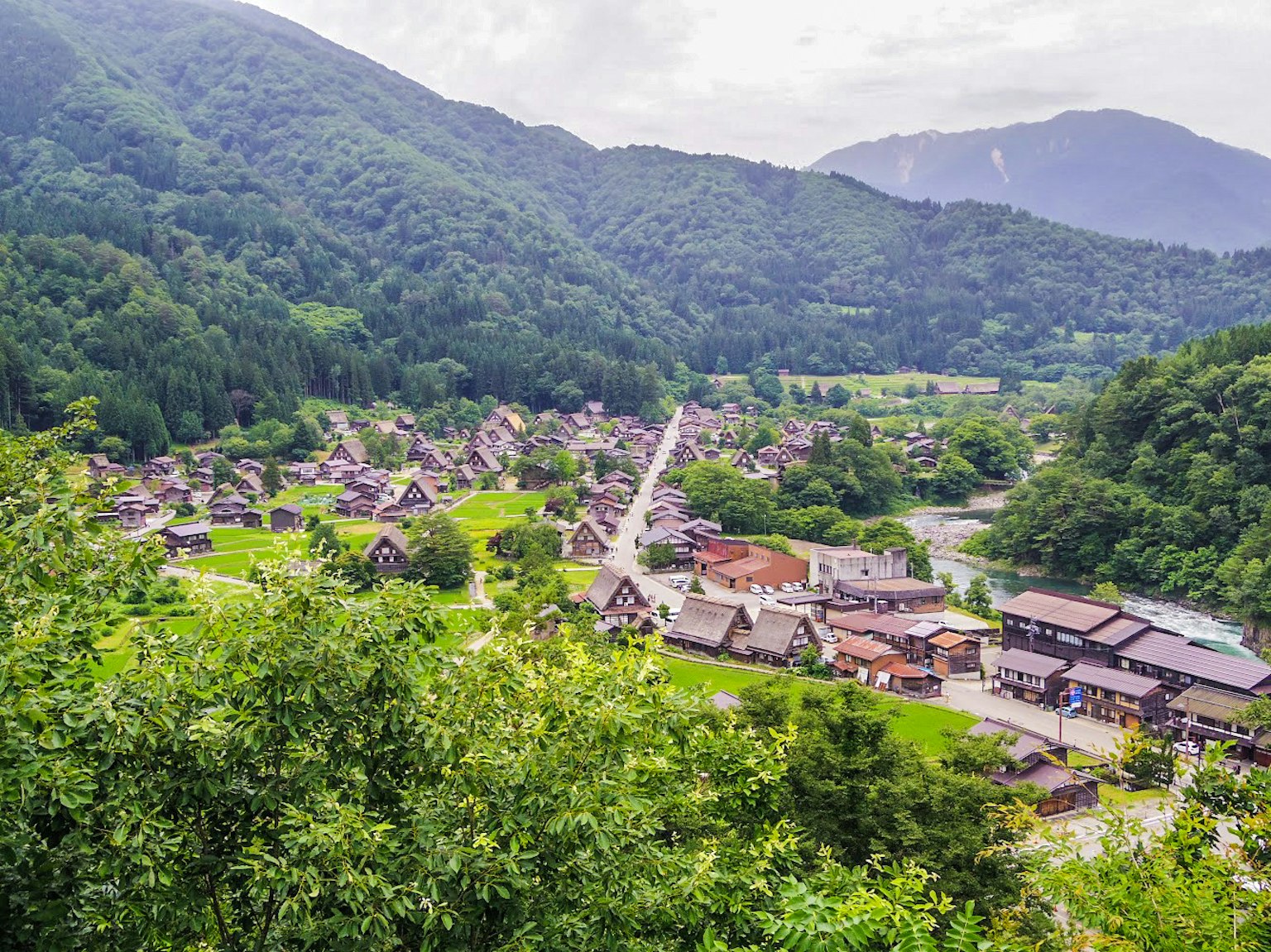 Vista panoramica di un villaggio circondato da montagne campi verdi e case tradizionali