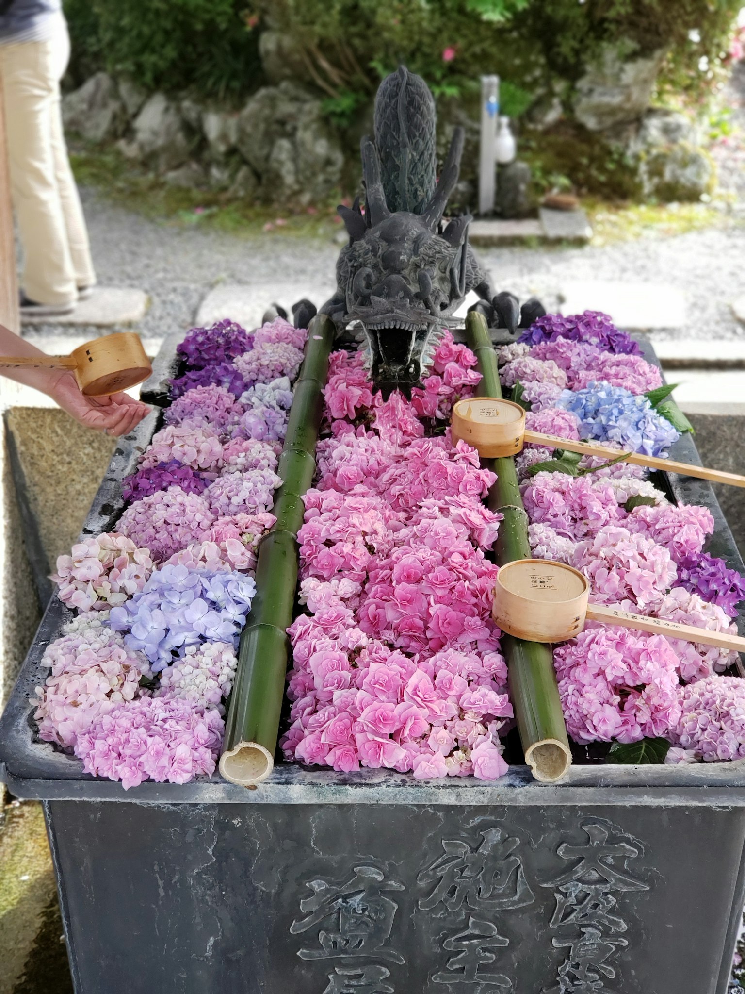 Water purification ritual site adorned with flowers bamboo water channels dragon sculpture