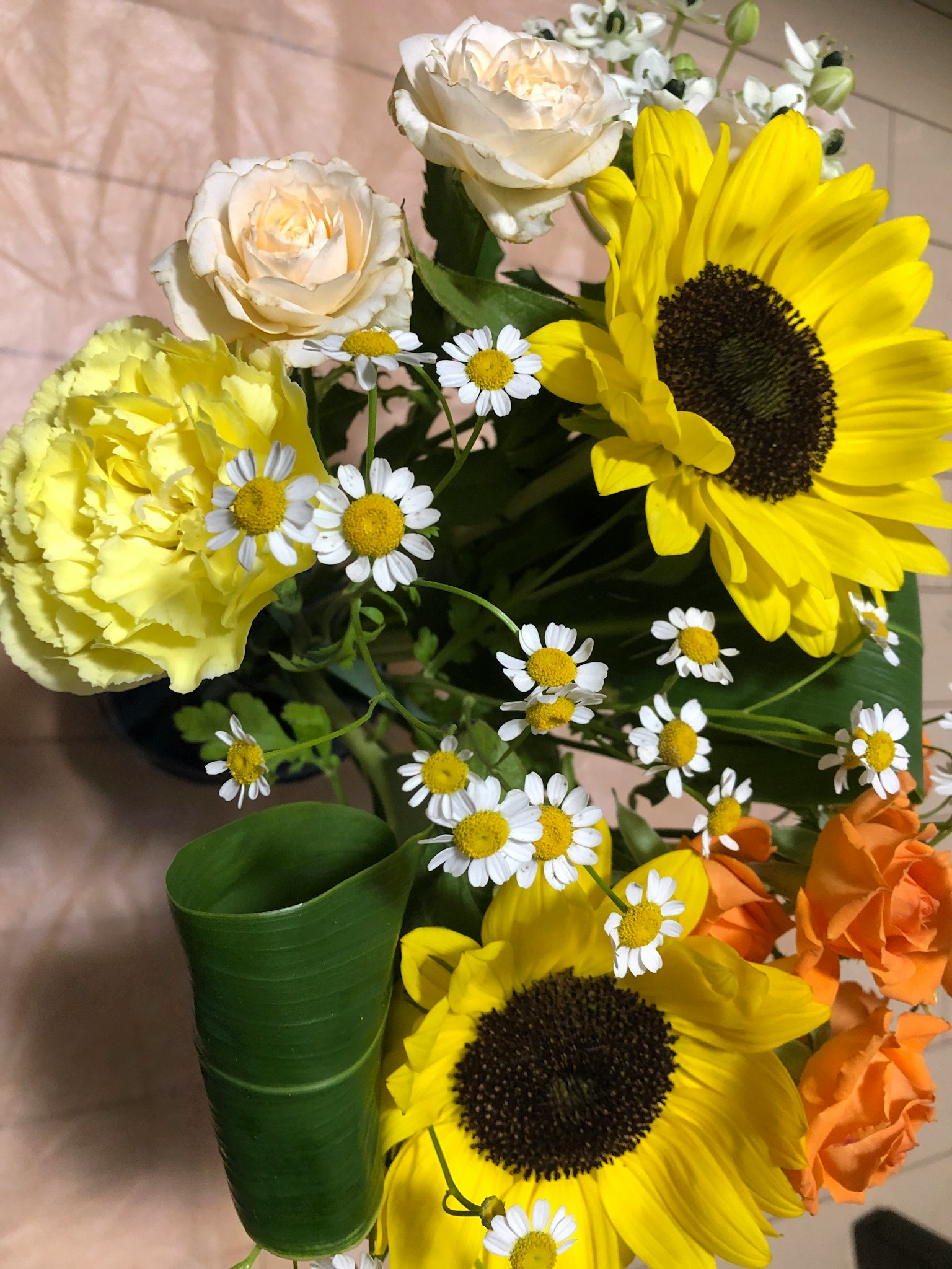 Anordnung von gelben Sonnenblumen und weißen Blumen
