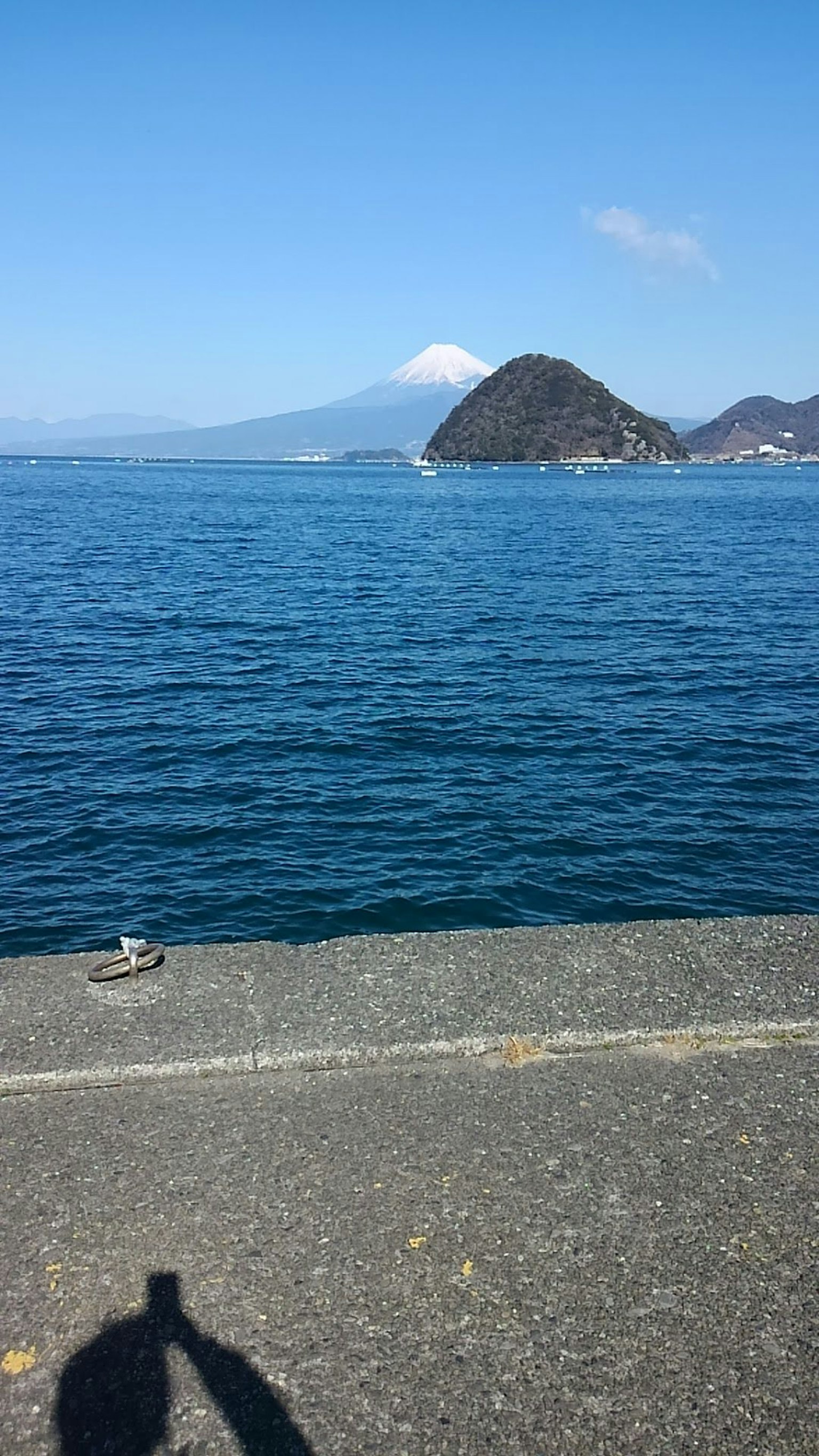 海邊景色，遠處可見富士山和前景的影子