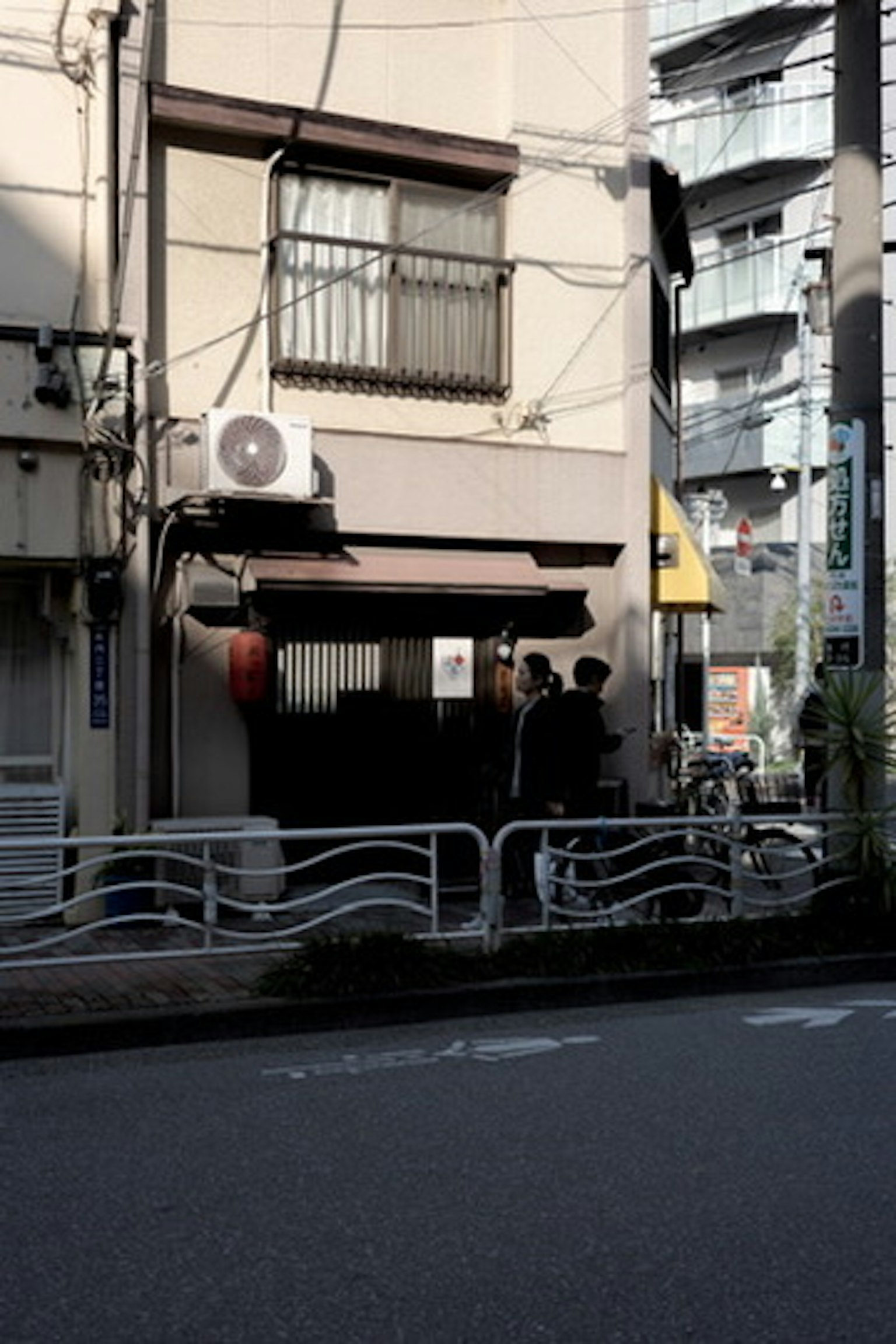 Fachada de un pequeño restaurante japonés en una calle estrecha