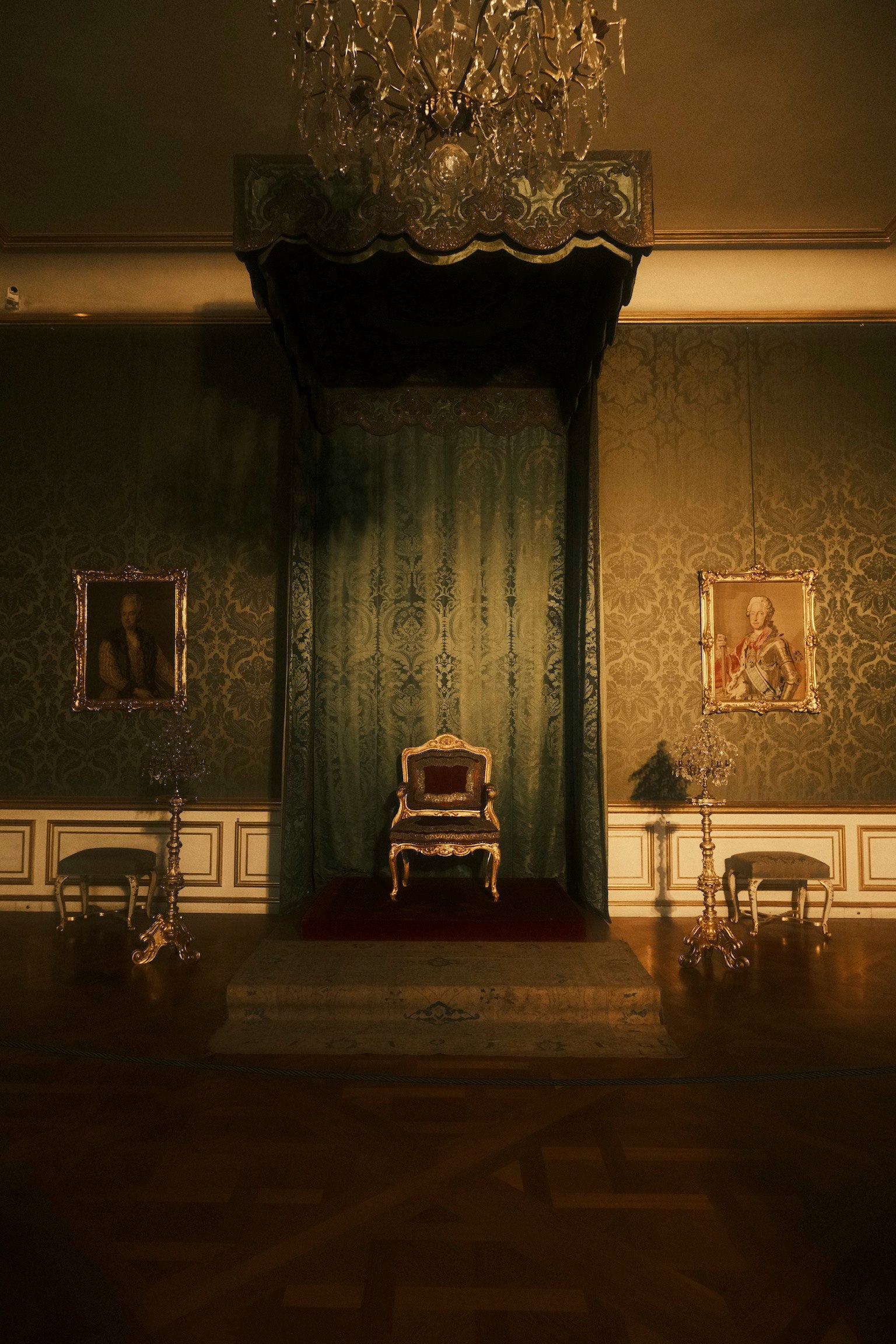 Un trône royal avec un rideau vert dans une pièce ornée
