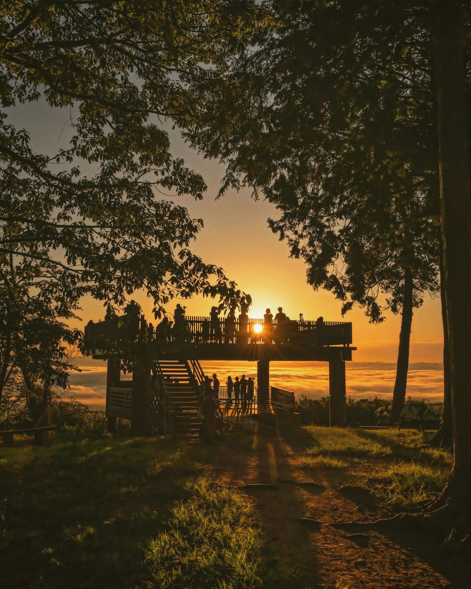 夕阳下的观景平台上聚集的人们剪影
