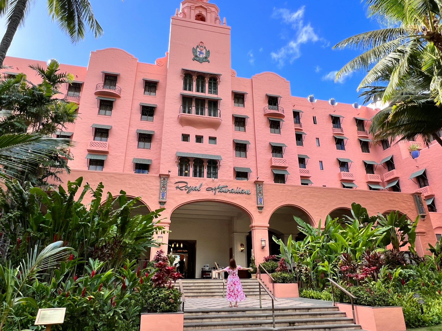 Cửa chính của Khách sạn Royal Hawaiian được bao quanh bởi cây nhiệt đới và mặt tiền màu hồng