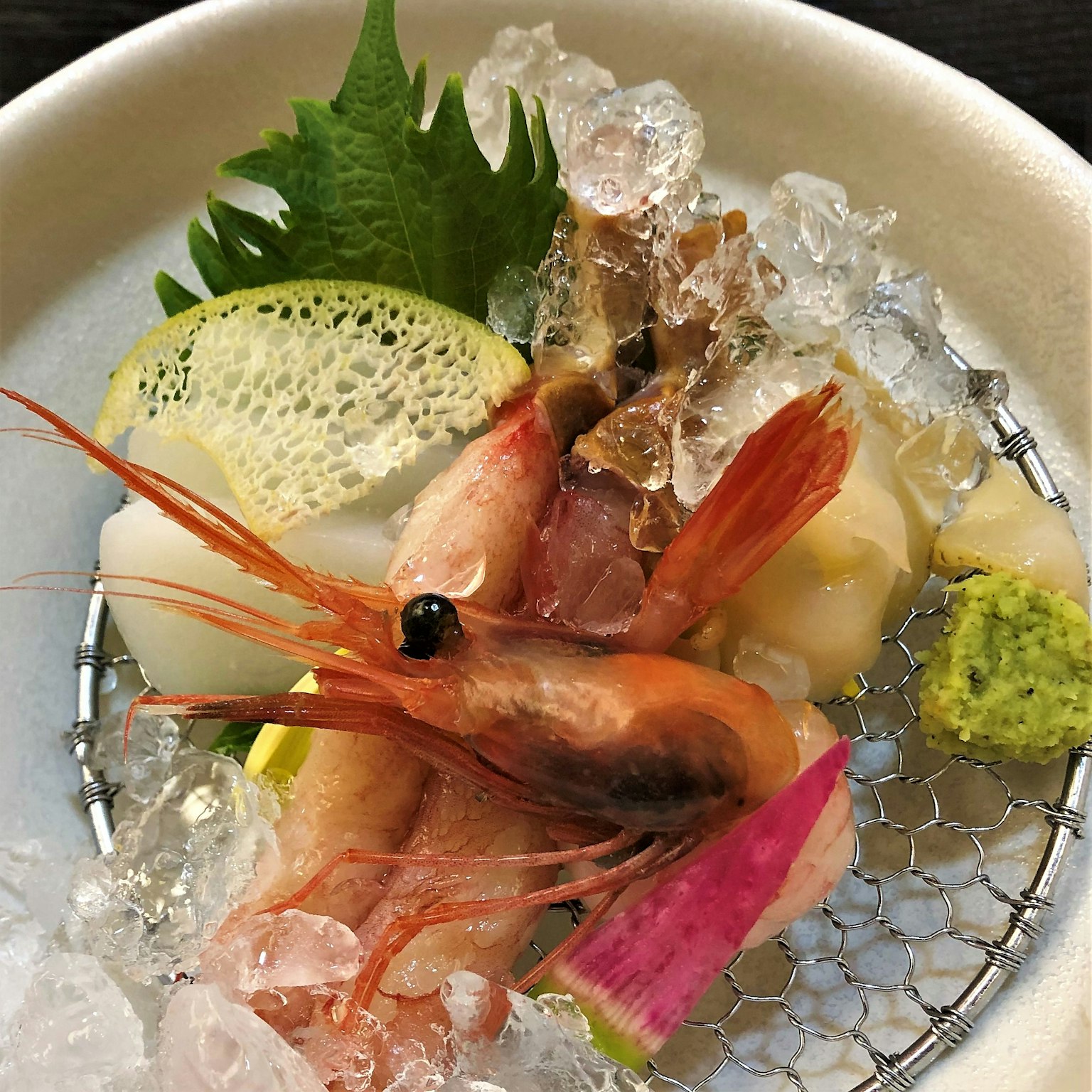 จานอาหารทะเลสดพร้อมกุ้งและเครื่องเคียงบนเกล็ดน้ำแข็ง