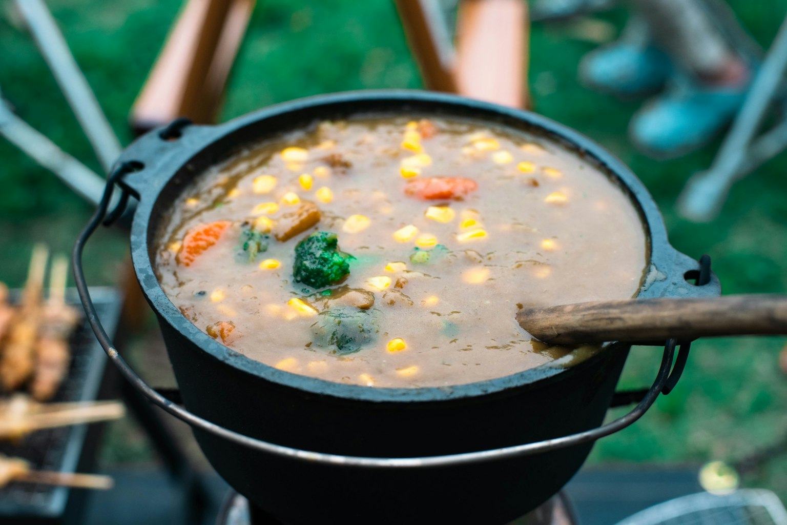 Une casserole noire remplie de légumes colorés et de soupe de maïs