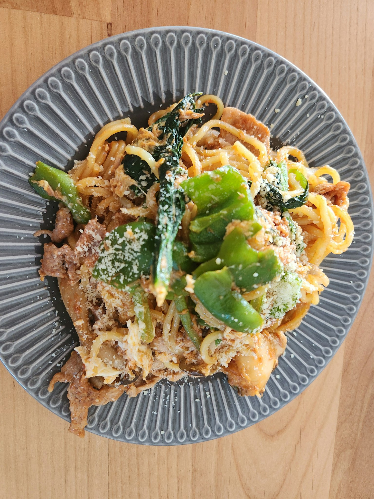 A plate of pasta with vegetables and cheese