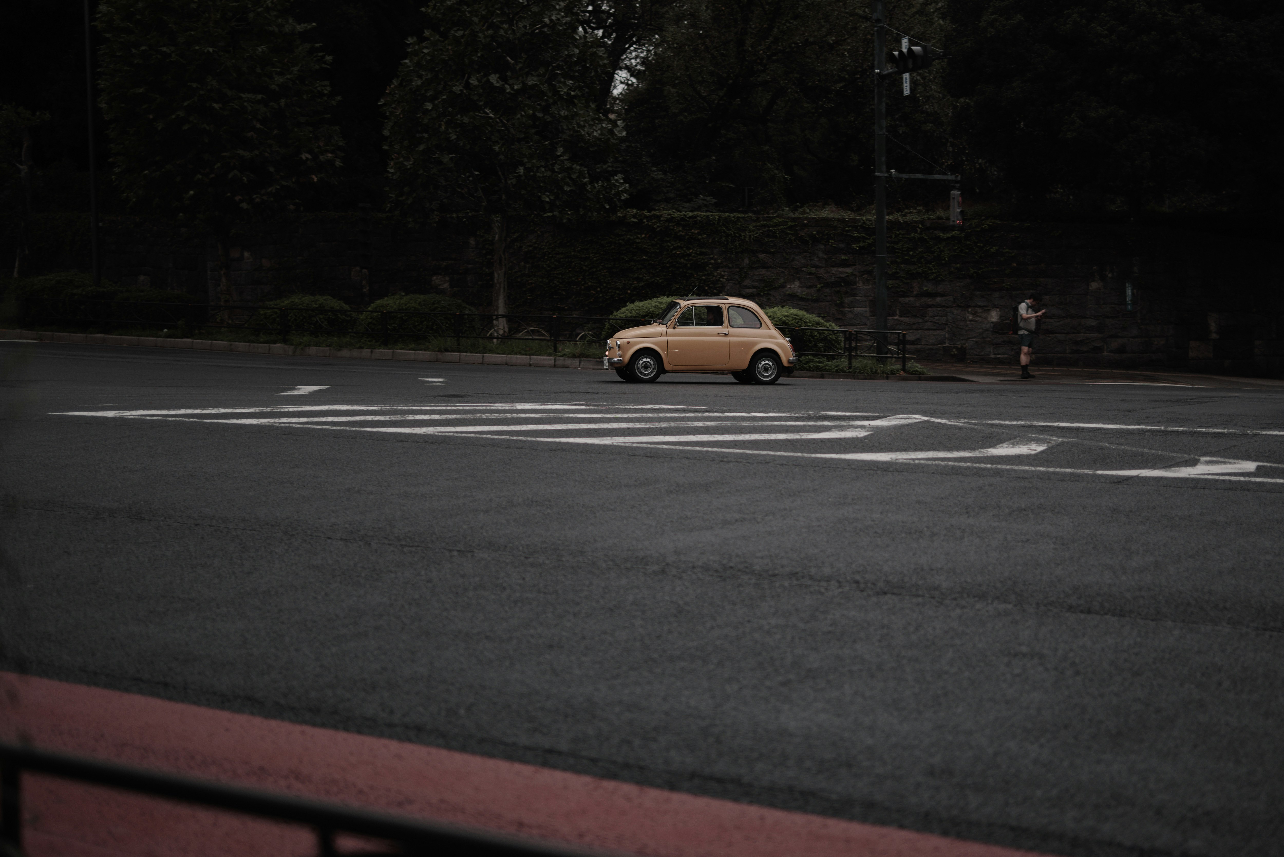 夜の交差点を走る黄色い車と街灯のある道路