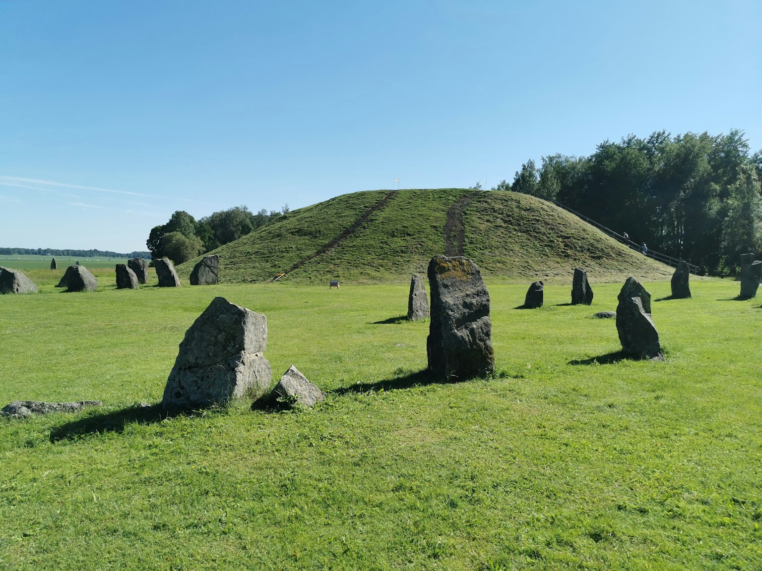 Círculo de piedras con montículo antiguo en pradera verde