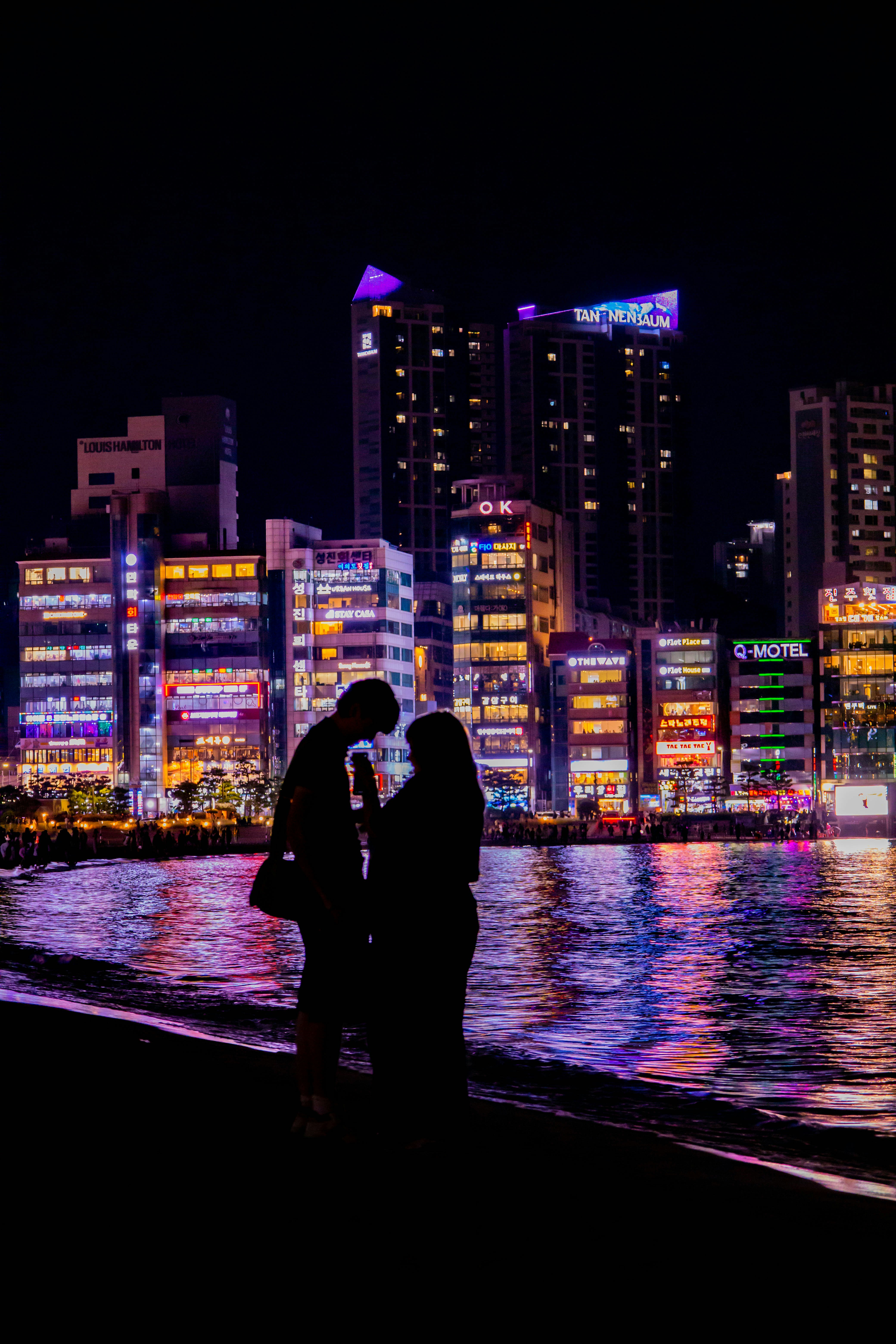 夜の海辺で寄り添うカップルのシルエット