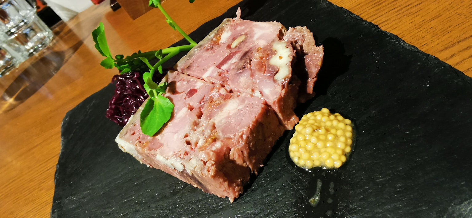在黑色石板上盛放的肉餅配芥末和裝飾