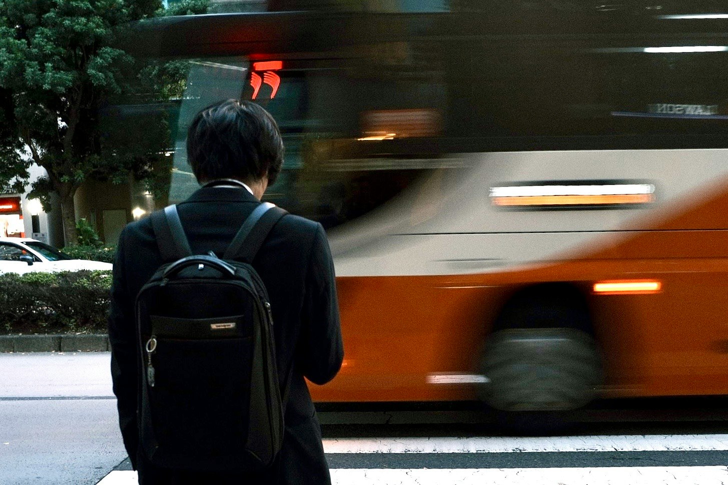 back view of a commuter with a passing train at a station
