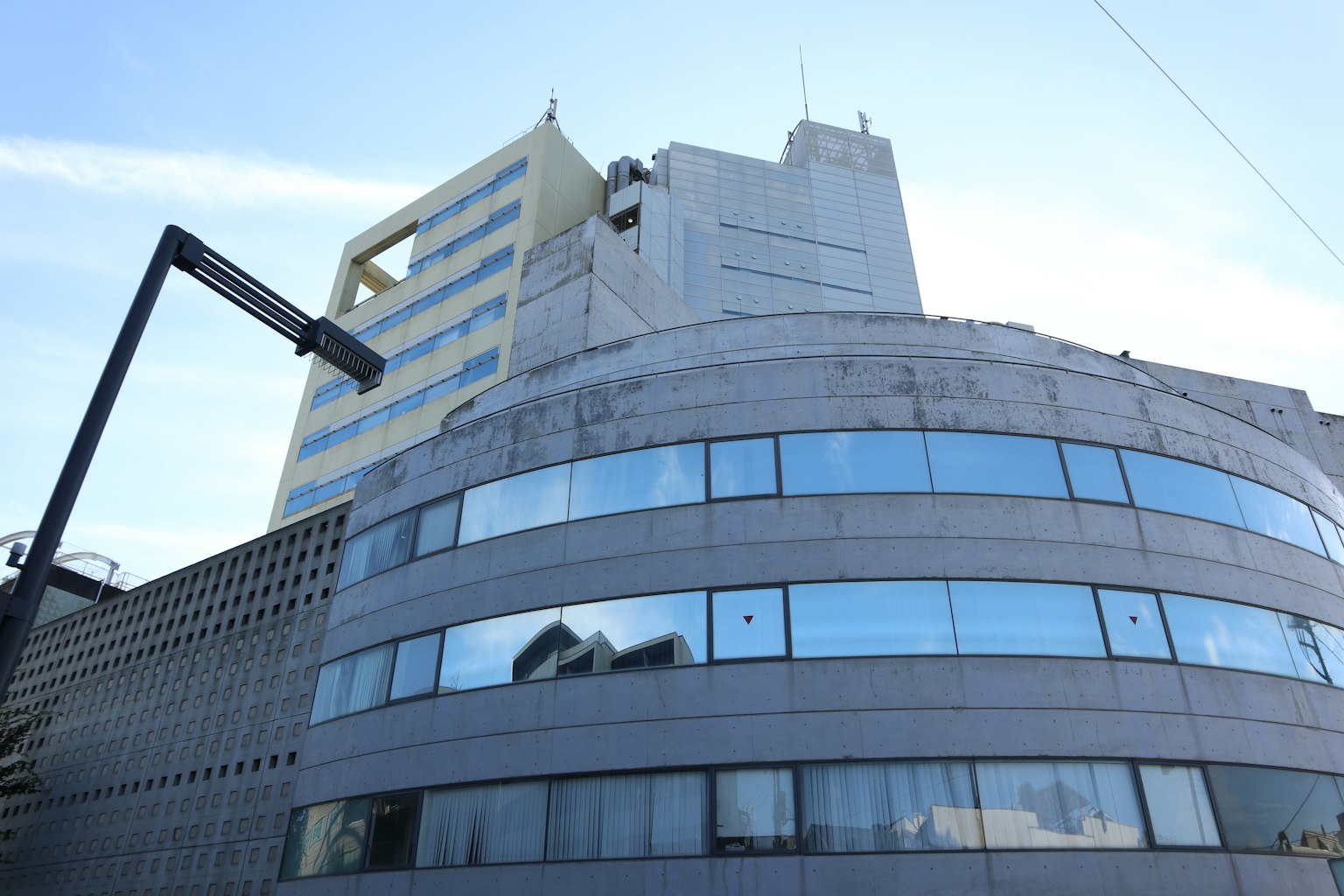 現代建築外觀，具有彎曲的玻璃窗和混凝土結構