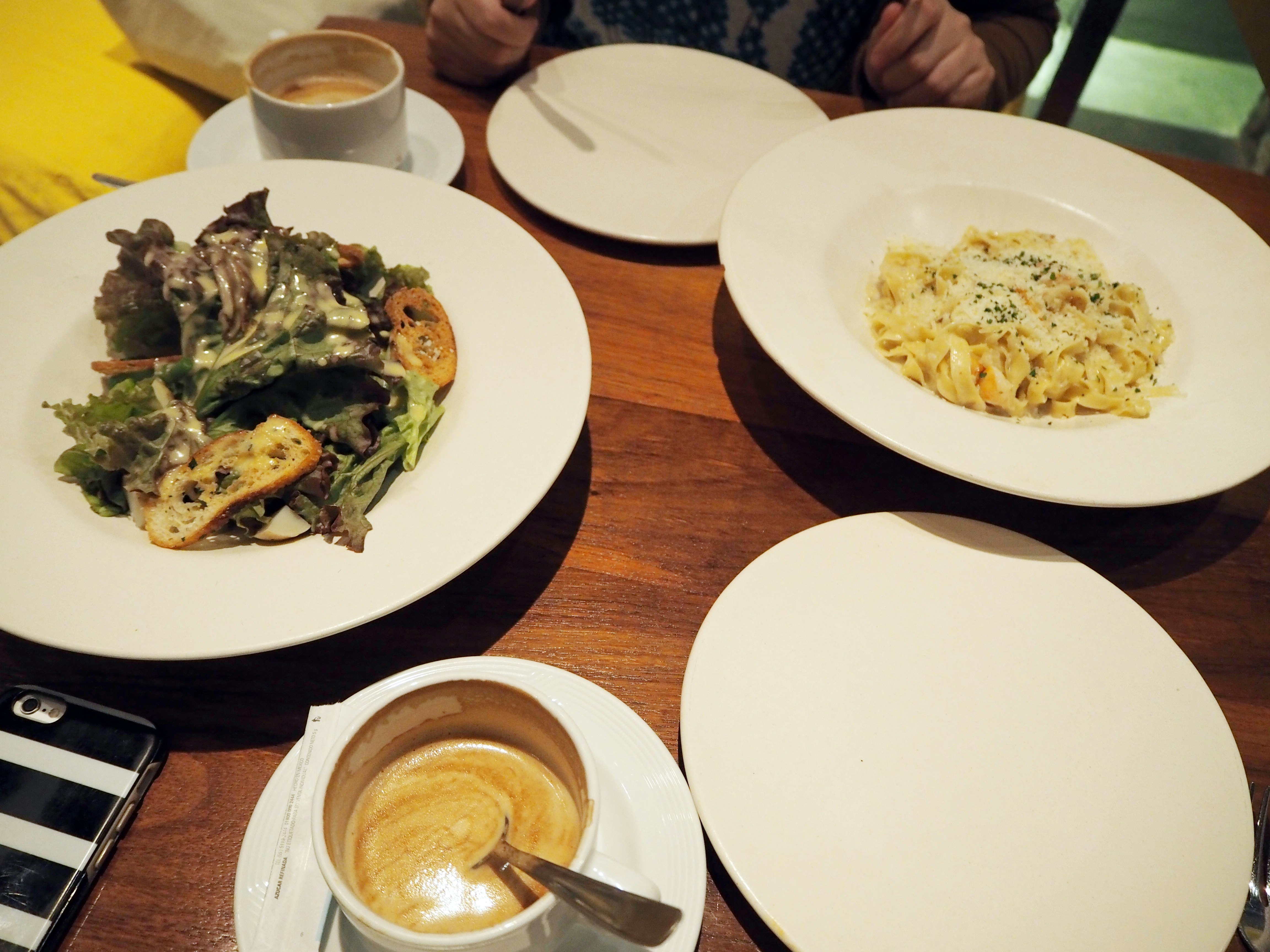 salade et pâtes sur une table en bois dans un café