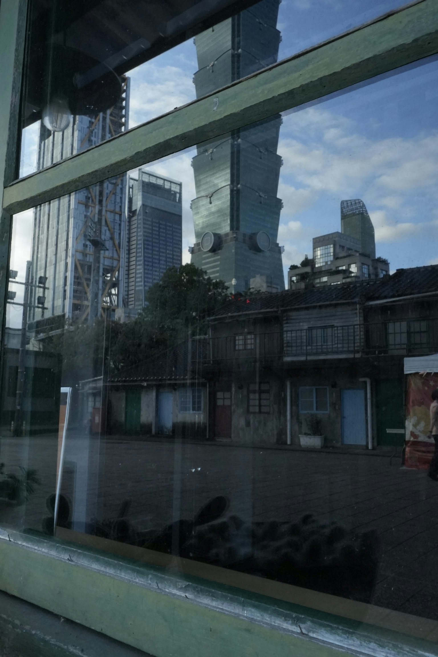 Reflection of buildings in a window showcasing a mix of old architecture and modern skyscrapers