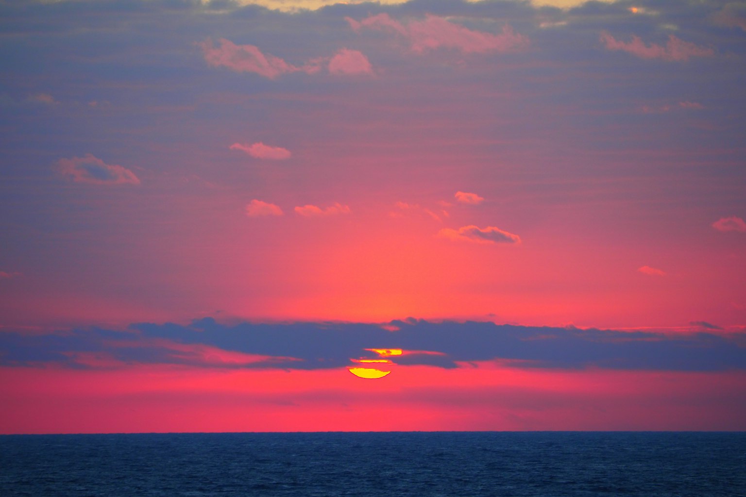 Beautiful landscape of sunset over the ocean with soft purple sky and orange sun