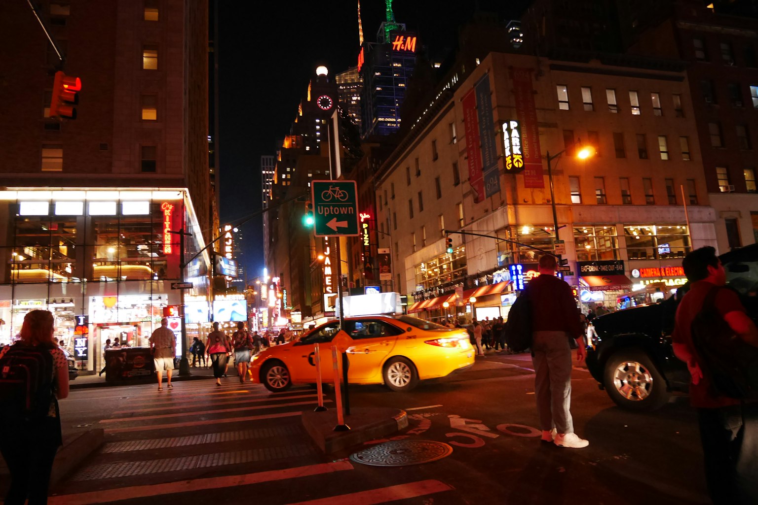 Intersección nocturna de Nueva York con taxi amarillo y peatones
