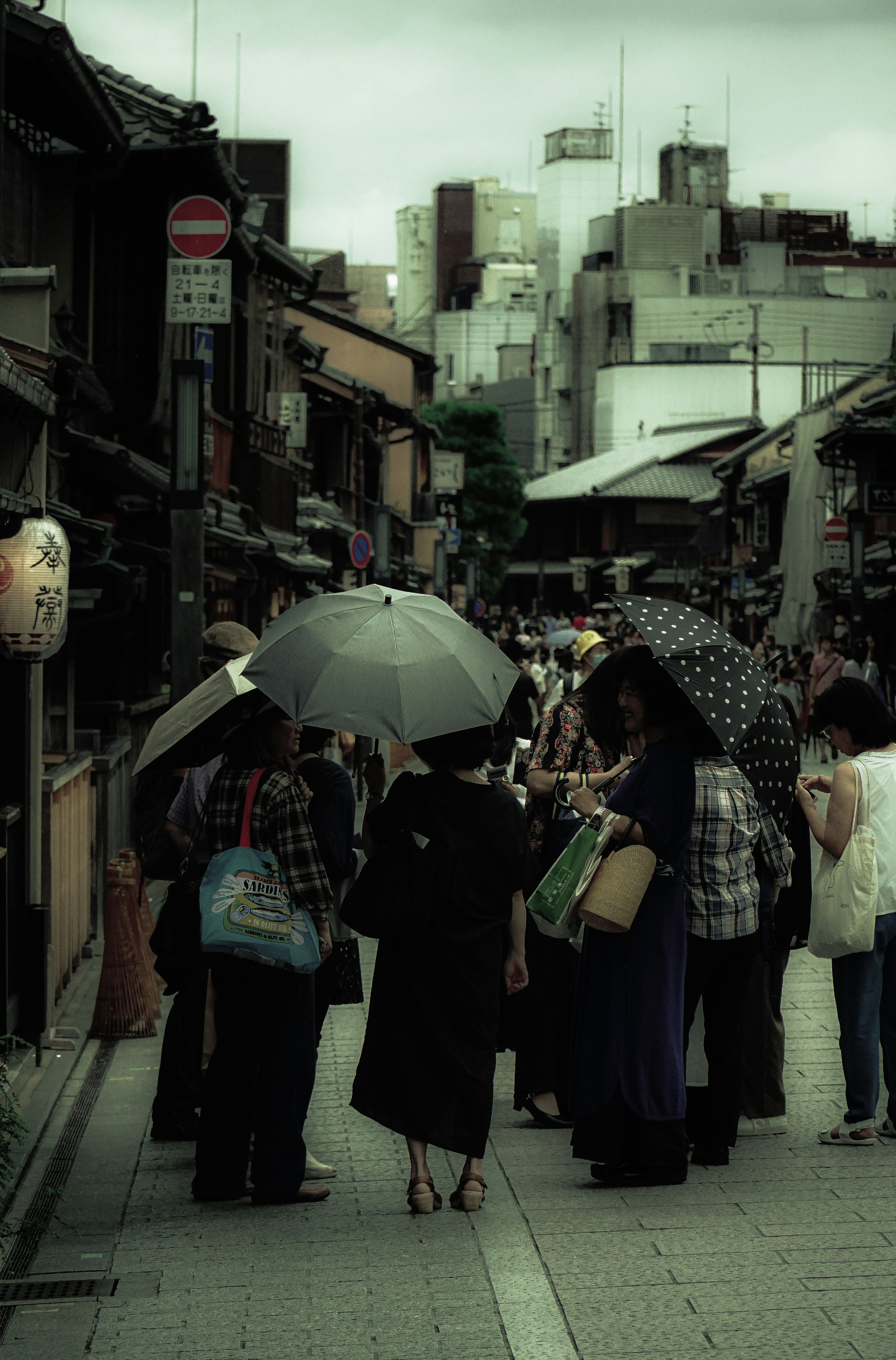 雨天商店街小巷里撑伞行走的人群