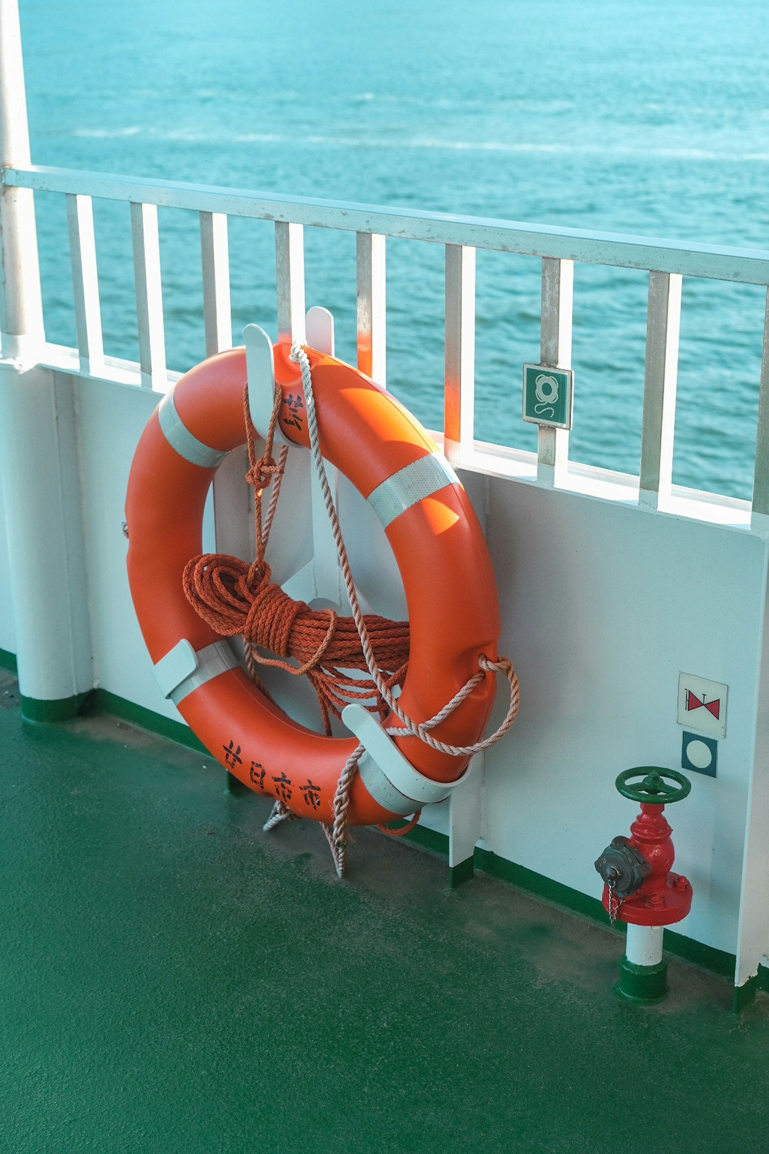 Giubbotto di salvataggio arancione montato sul ponte di una nave con un idrante vicino