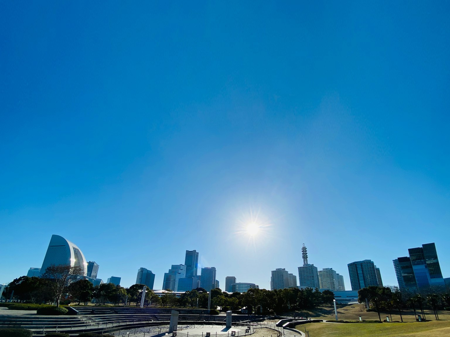 城市天際線高樓大廈在晴朗的藍天下明亮的太陽在背景中