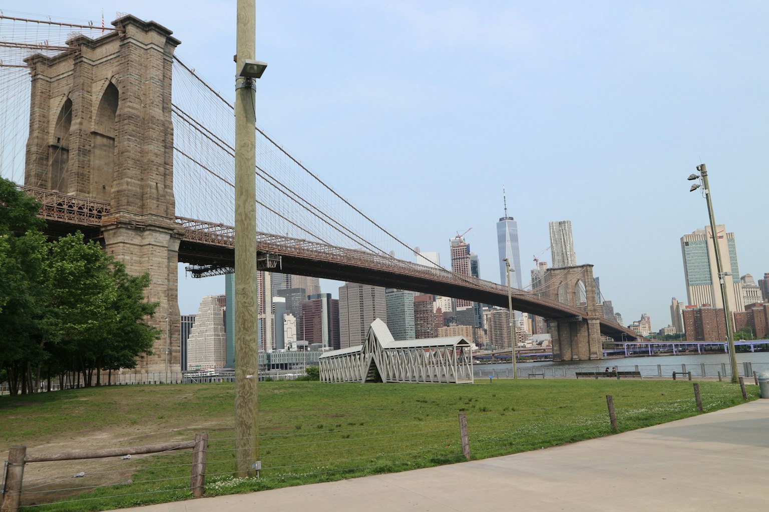 Ponte di Brooklyn con lo skyline di New York sullo sfondo e un parco verde
