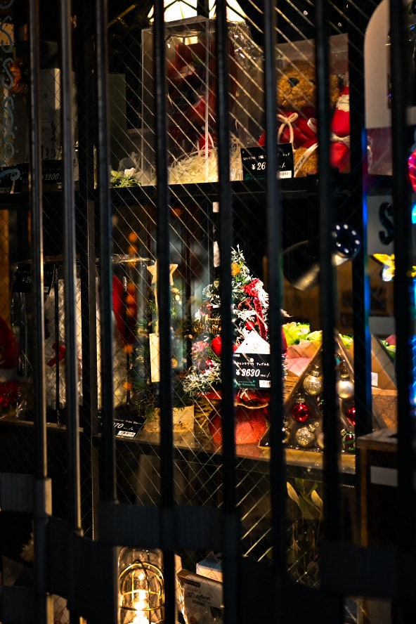 クリスマス飾りのある店先のガラス越しの夜景