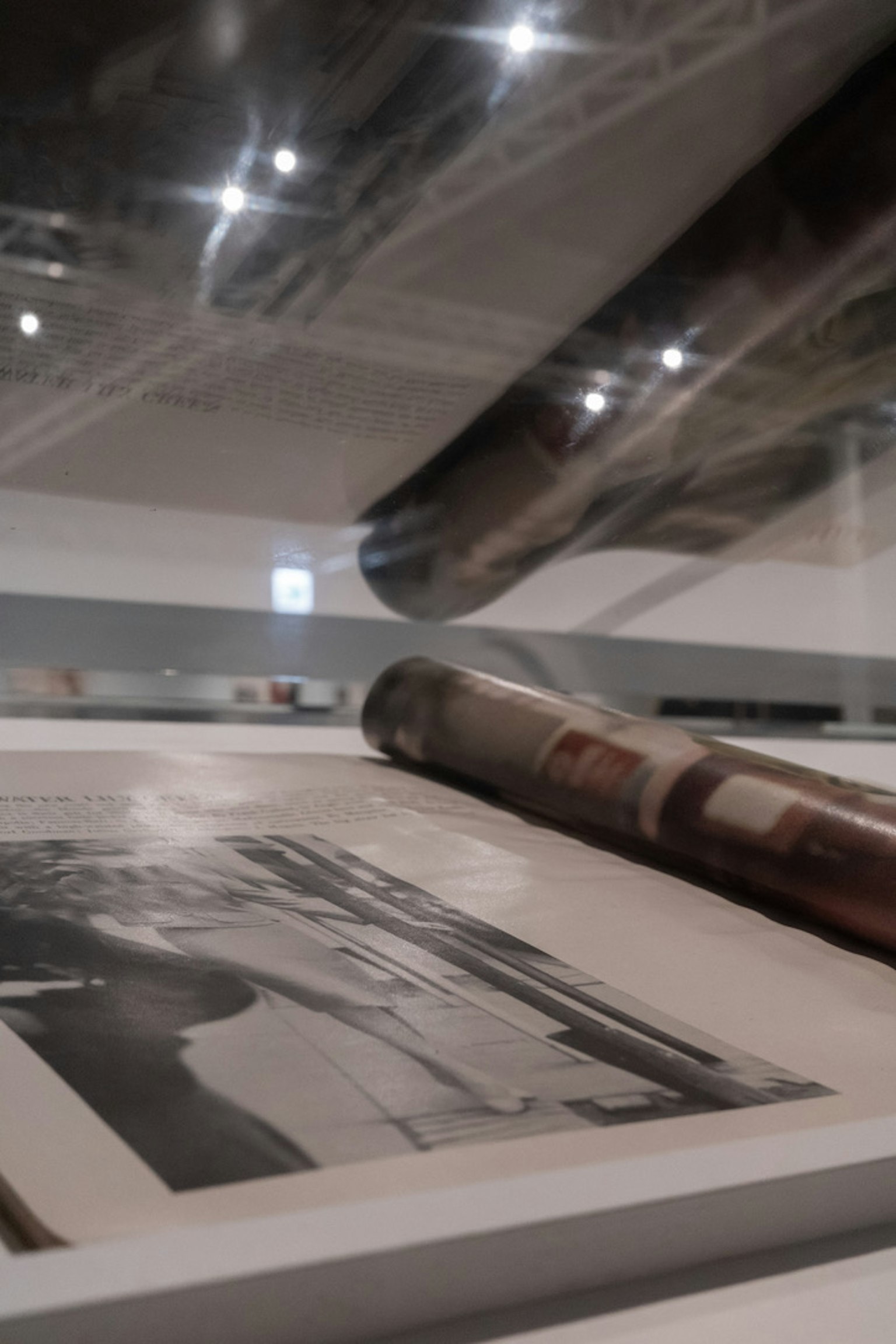 Intérieur d'un espace d'exposition avec une vieille photographie et des impressions enroulées