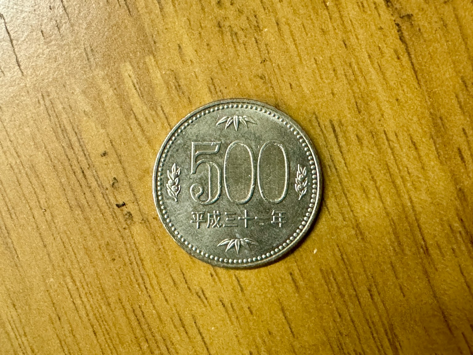 Pièce de 500 yens placée sur une table en bois