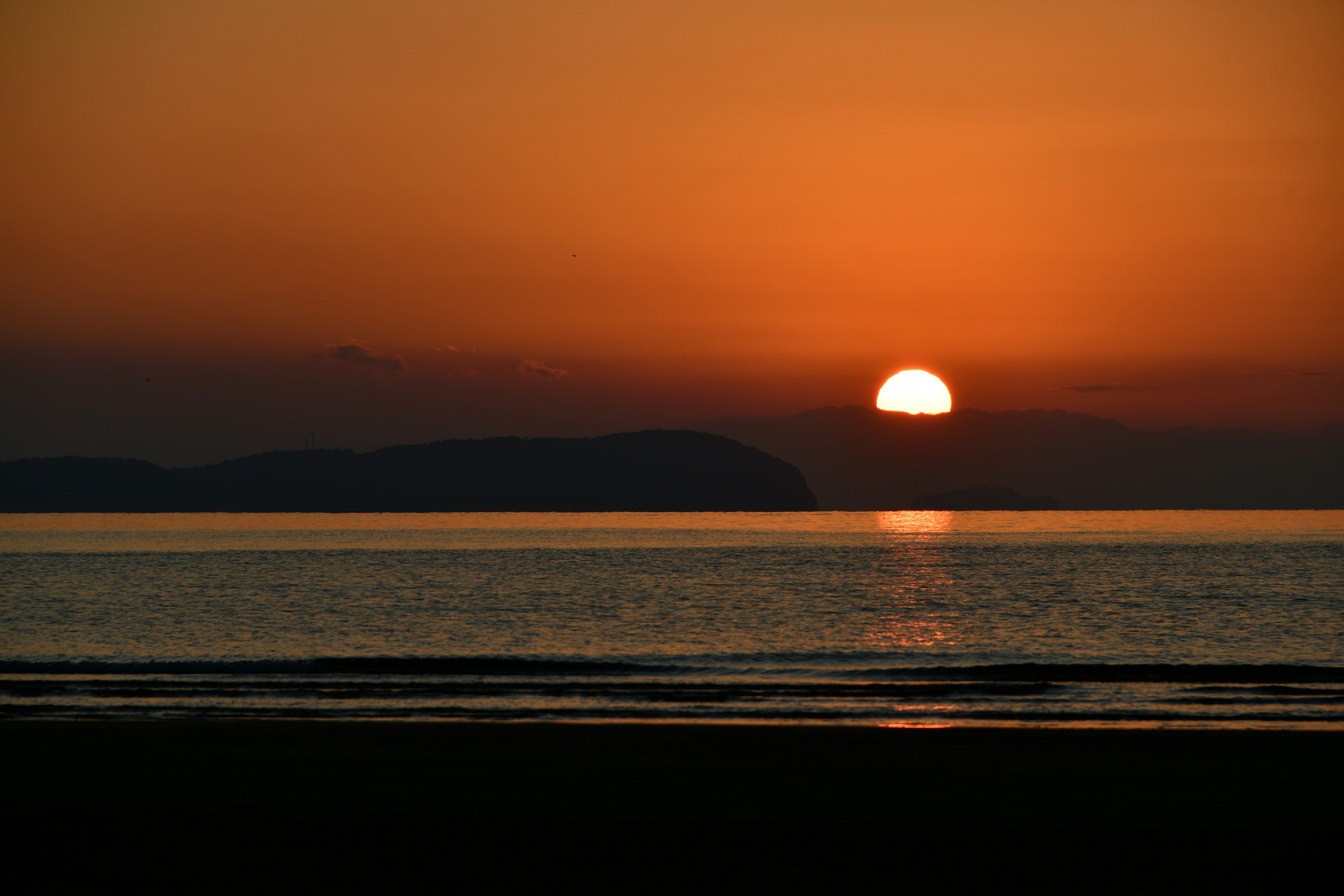 Sonnenuntergang über dem Ozean mit Wellen und Horizont