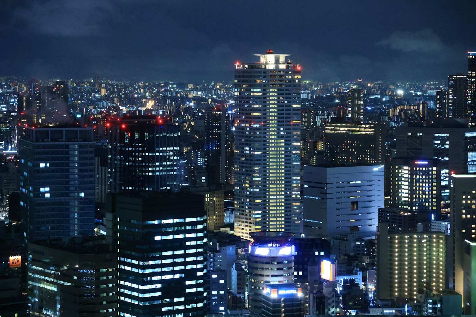 Horizonte urbano nocturno con rascacielos iluminados y luces de neón vibrantes