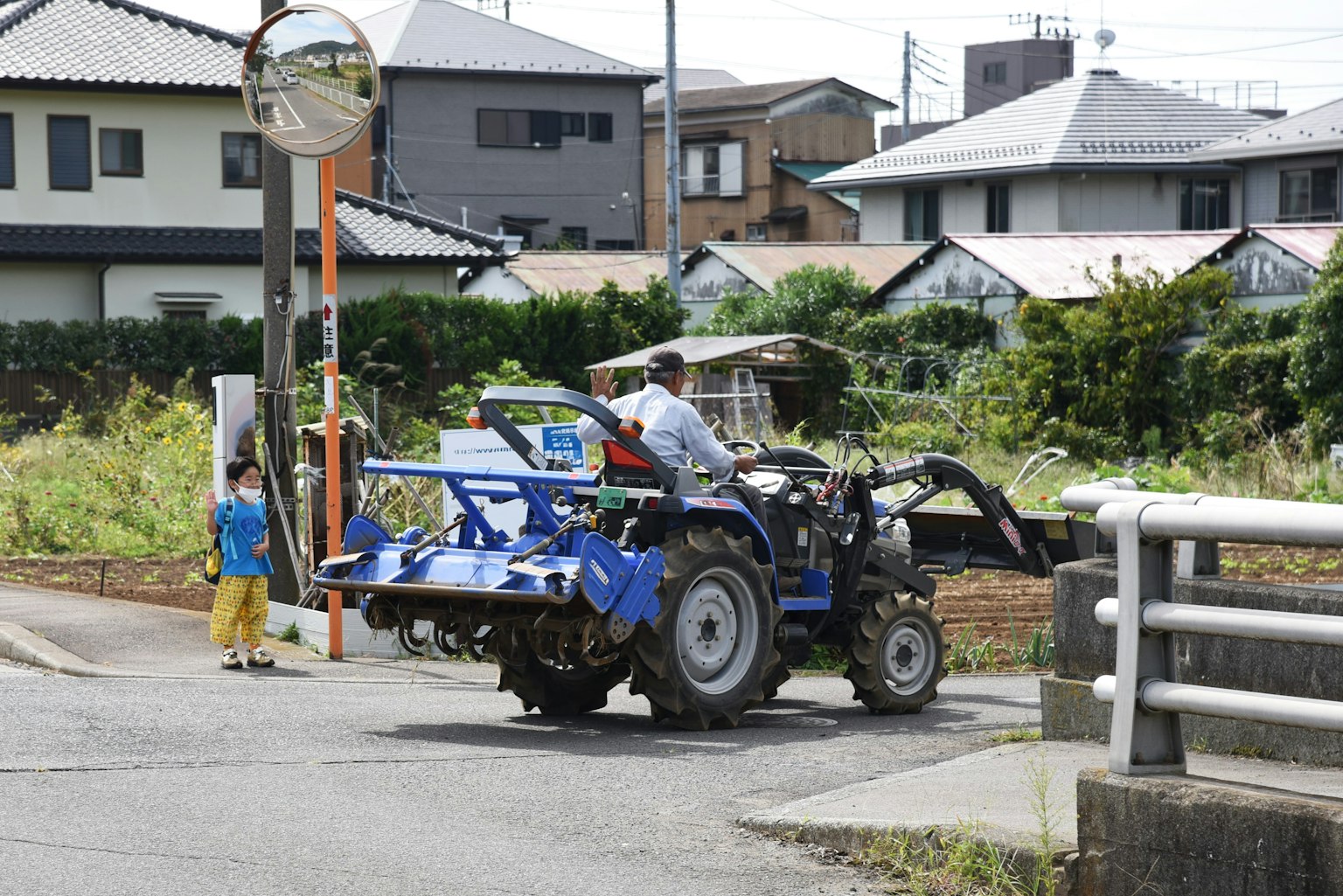 一辆蓝色拖拉机在乡村农田场景中行驶