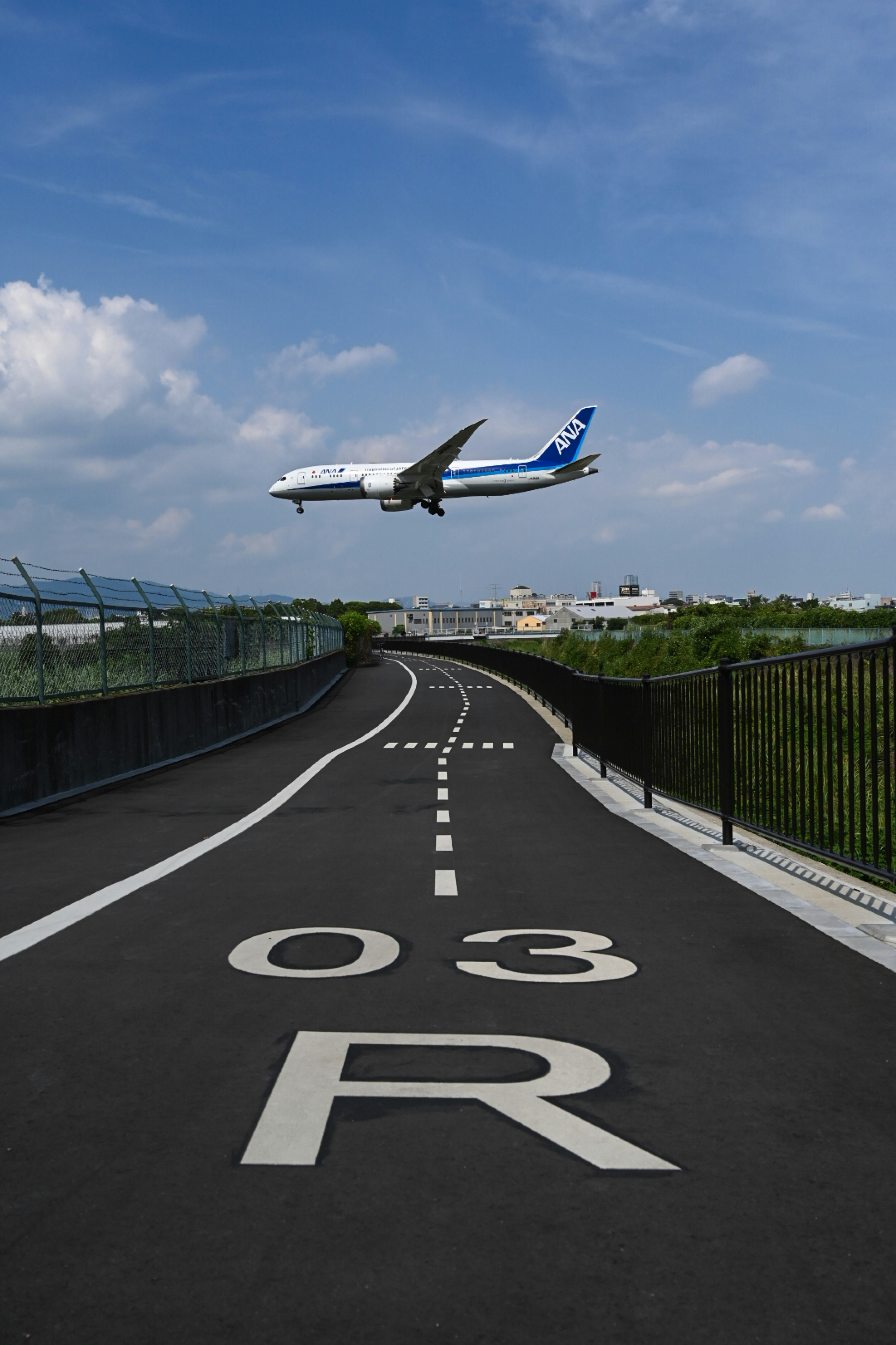 整備工事後にリニューアルされた千里川土手の道路に飛行機が入る瞬間